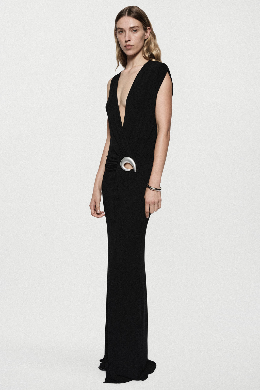 Black sleeveless plunging maxi dress with draped front and silver ring belt