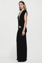 Black sleeveless plunging maxi dress with draped sides and silver ring belt