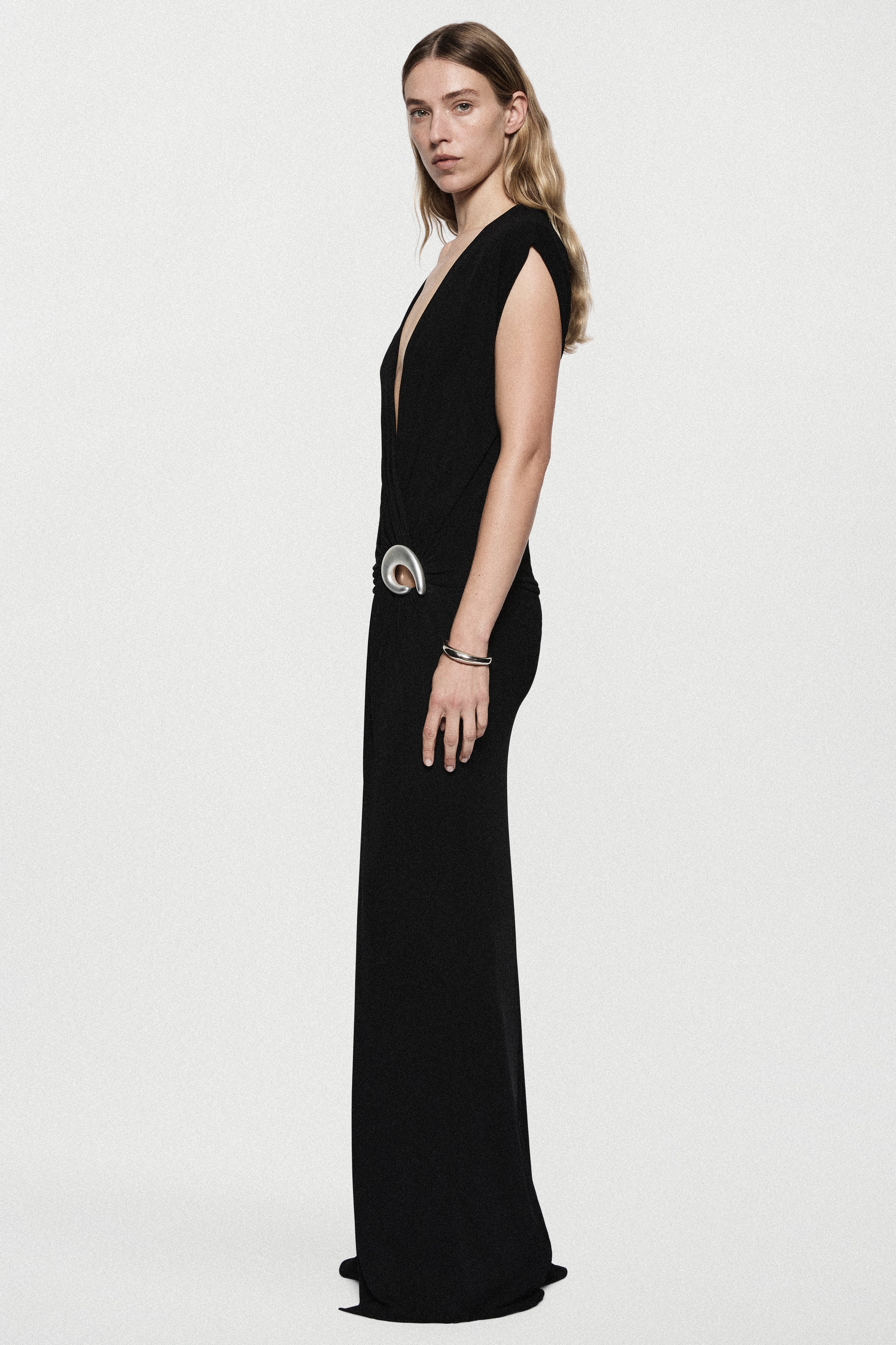 Black sleeveless plunging maxi dress with draped wrap detail and silver ring belt