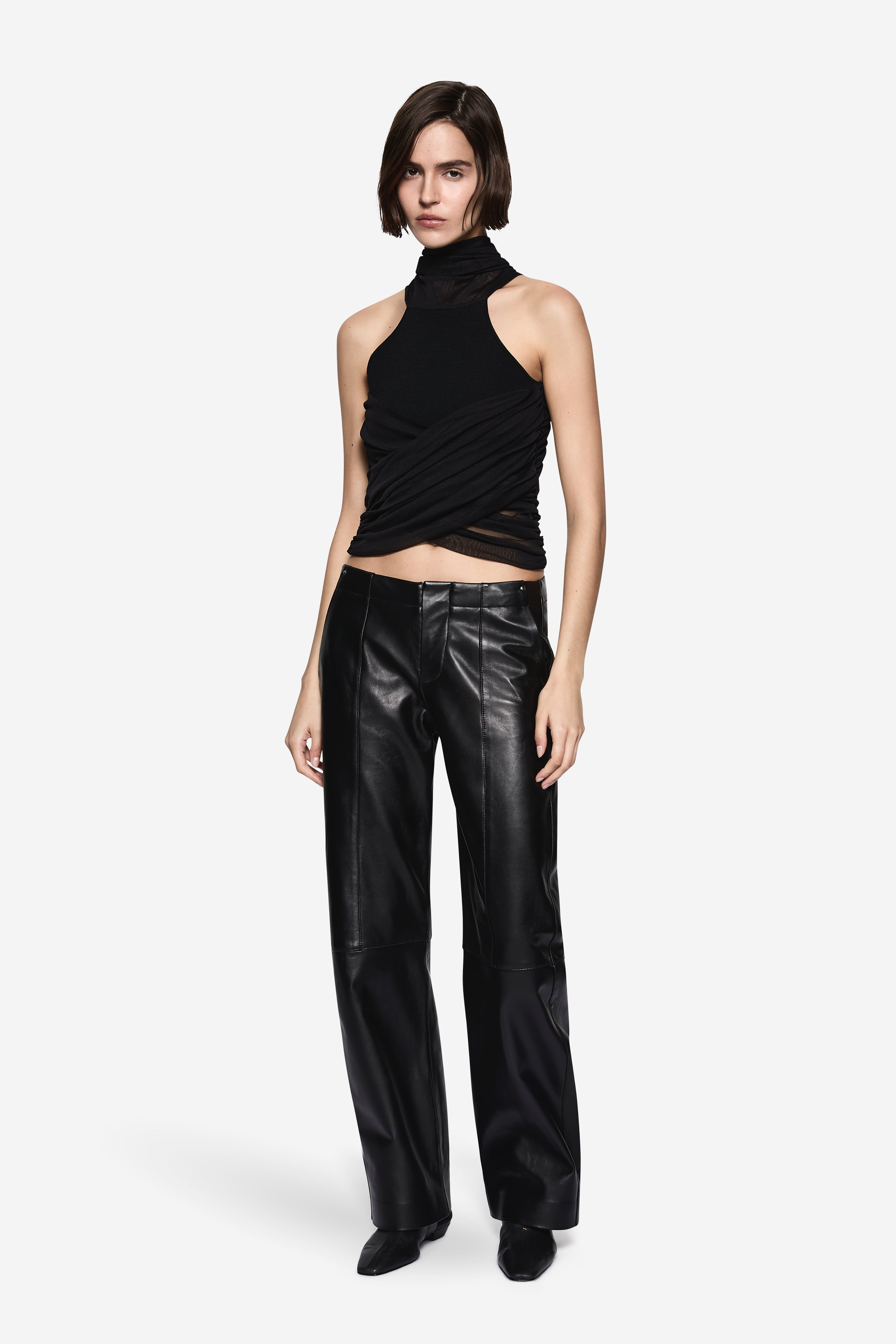 Black compact knit halter top with draped wrap front and high neckline