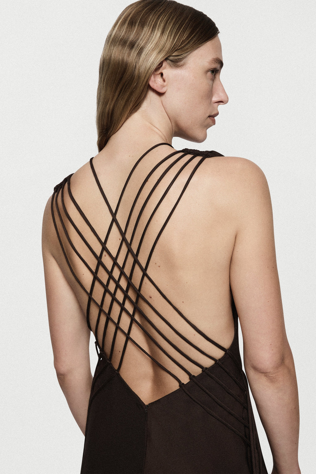 Backless dark brown satin plunge gown with crisscross strap design, long silhouette