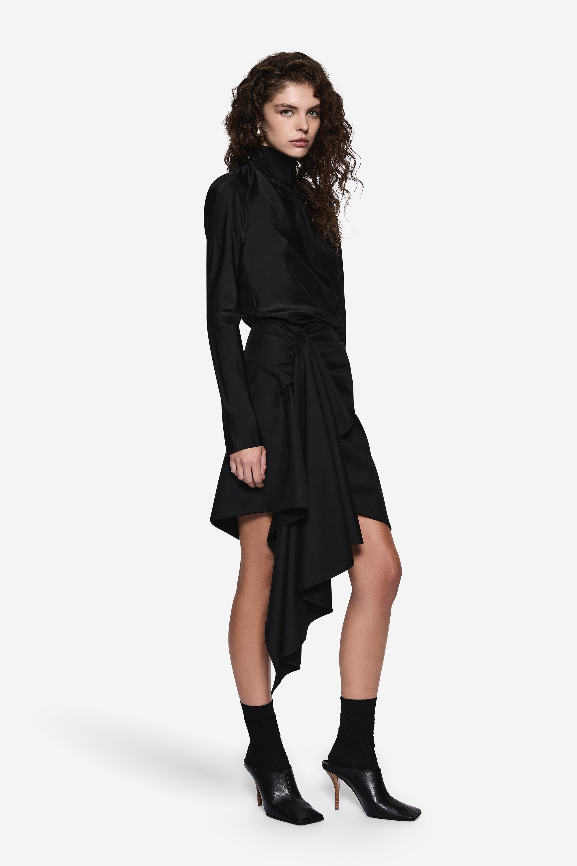 Black sheer silk blouse with high neck, long sleeves, and tied asymmetrical wrap