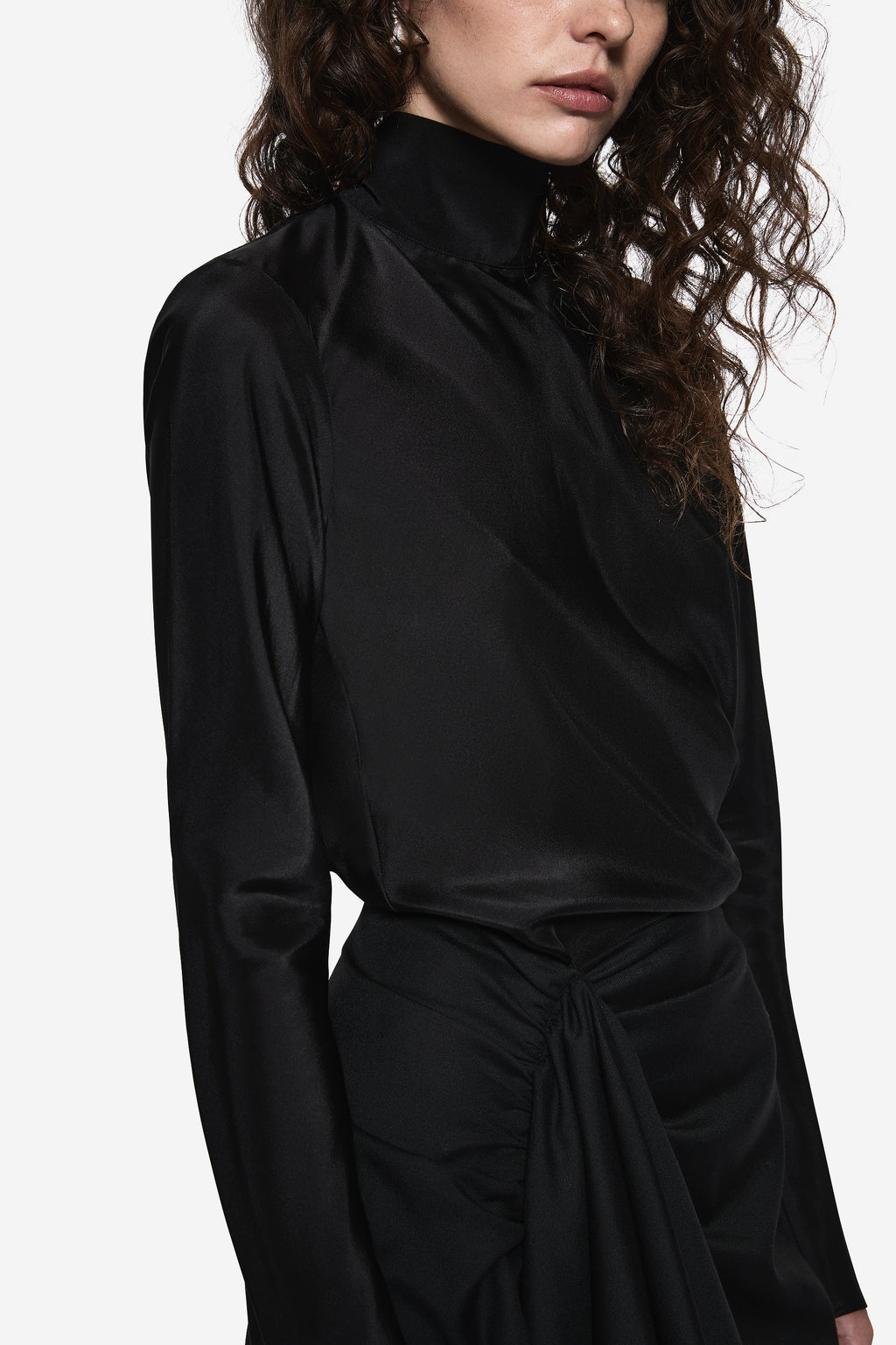 Black sheer silk blouse with high neck, long sleeves, and tied waist detail