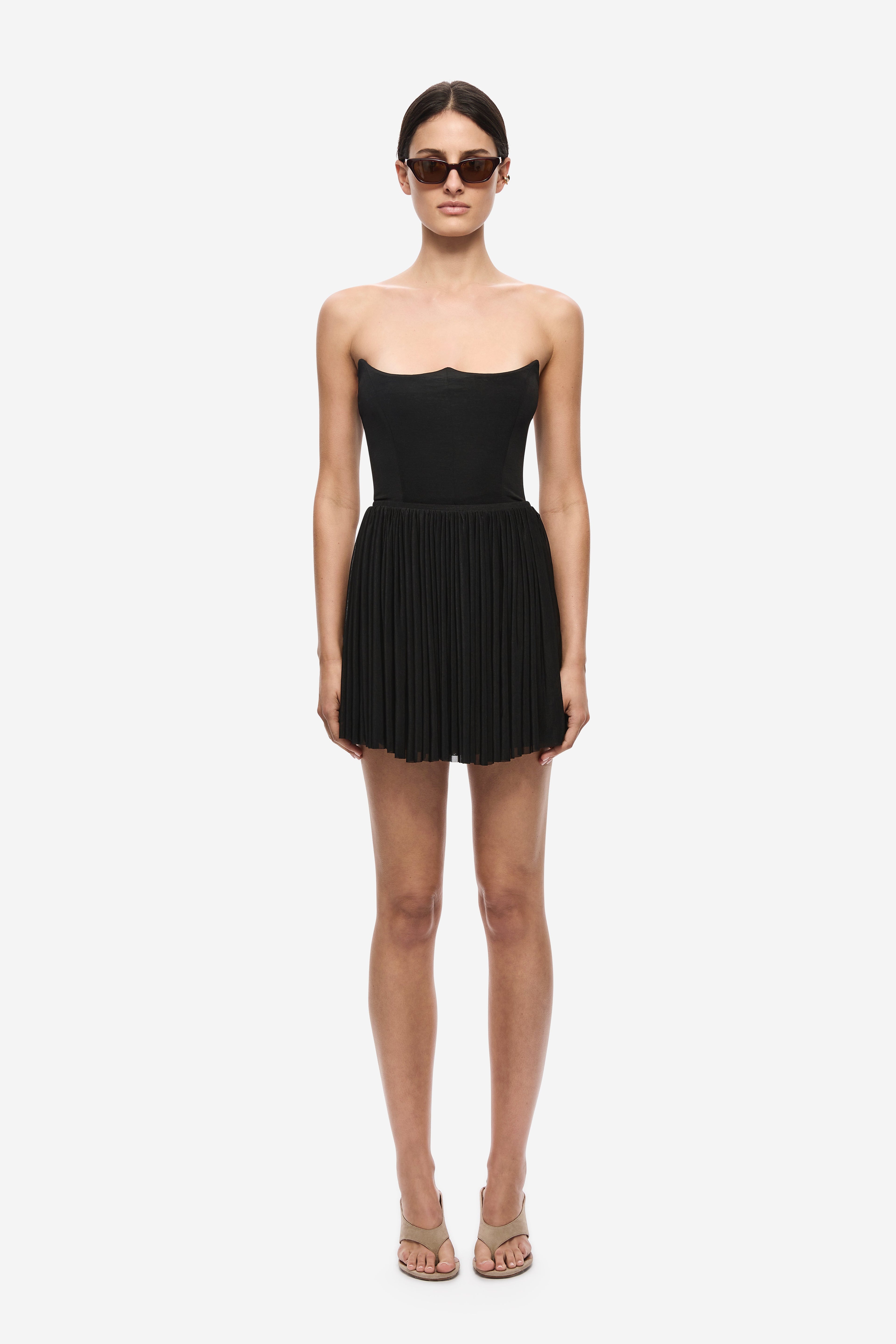 Black gathered jersey mini skirt with elastic waistband and finely pleated texture.