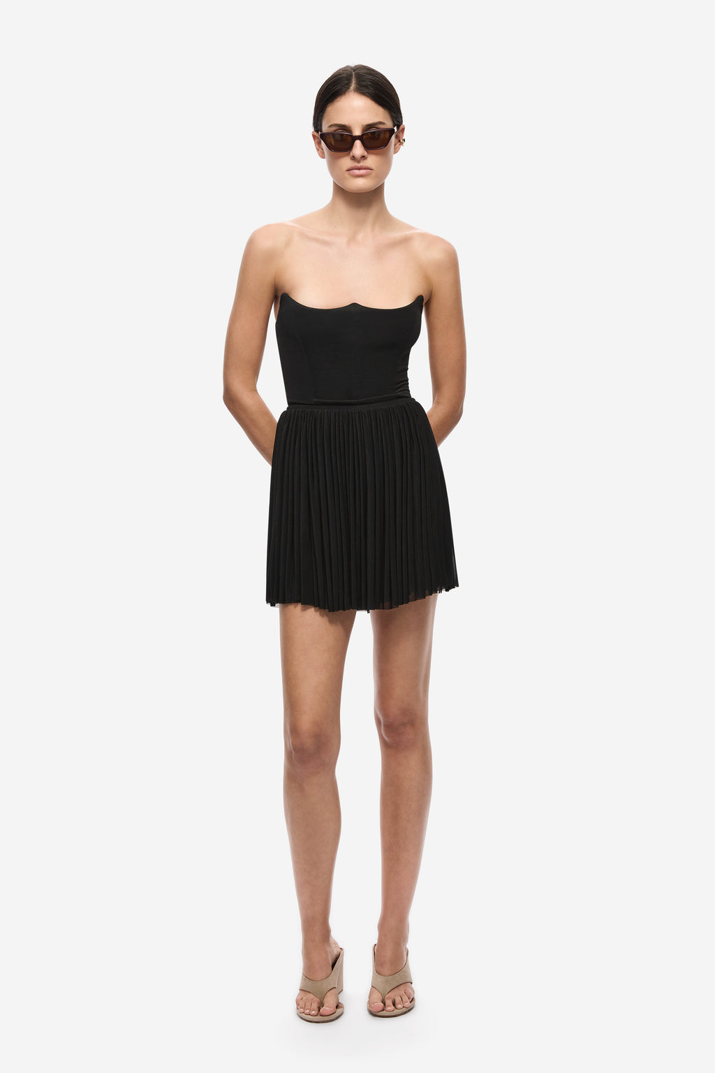 Black gathered jersey mini skirt with elastic waistband and pleated, gathered hem.