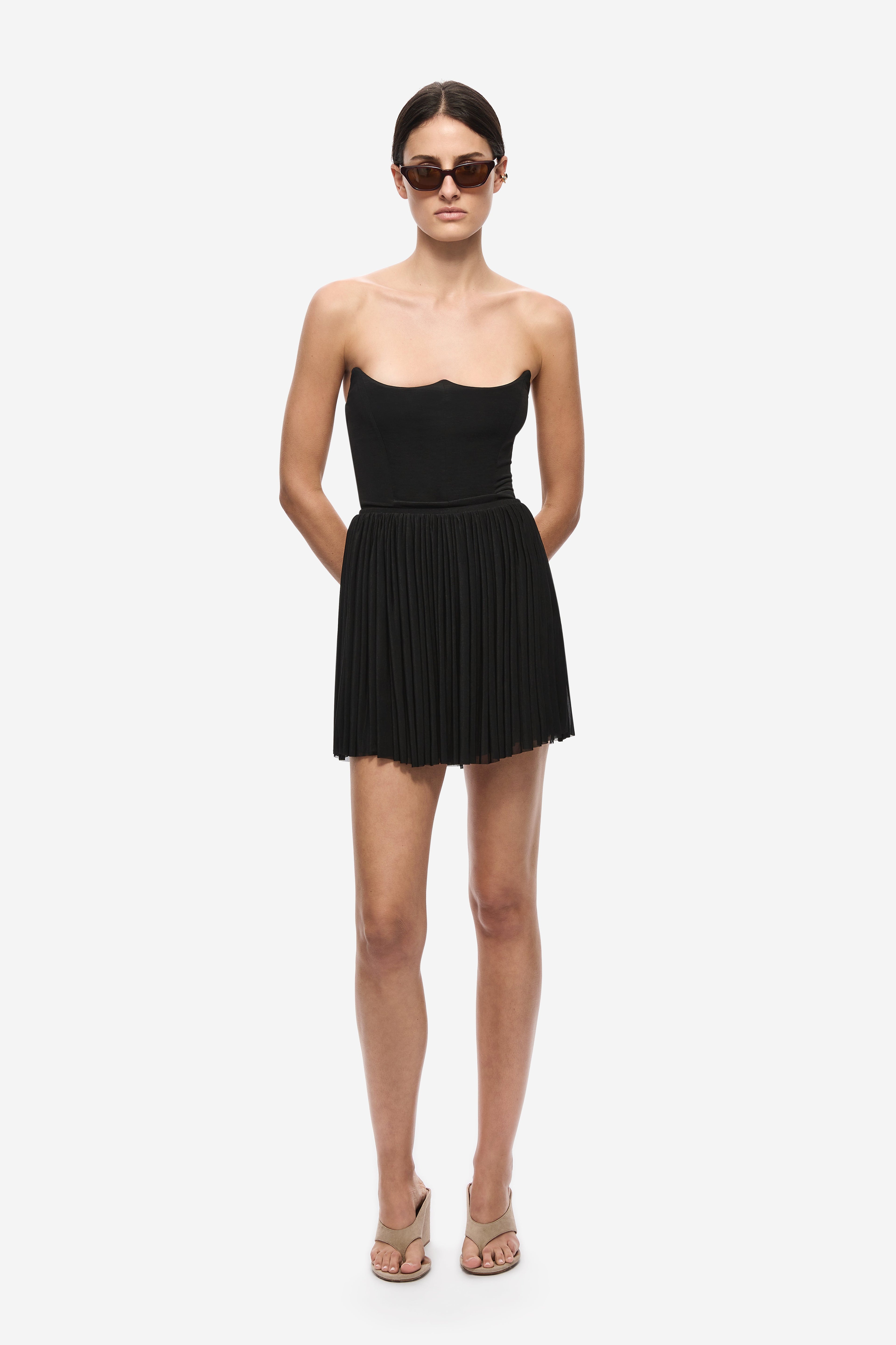 Black gathered jersey mini skirt with elastic waistband and pleated, gathered hem.