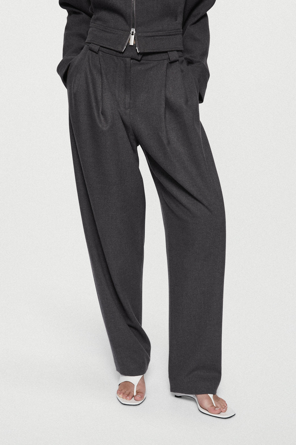 Charcoal tailored trousers with zip fly, pleated front, and tapered leg