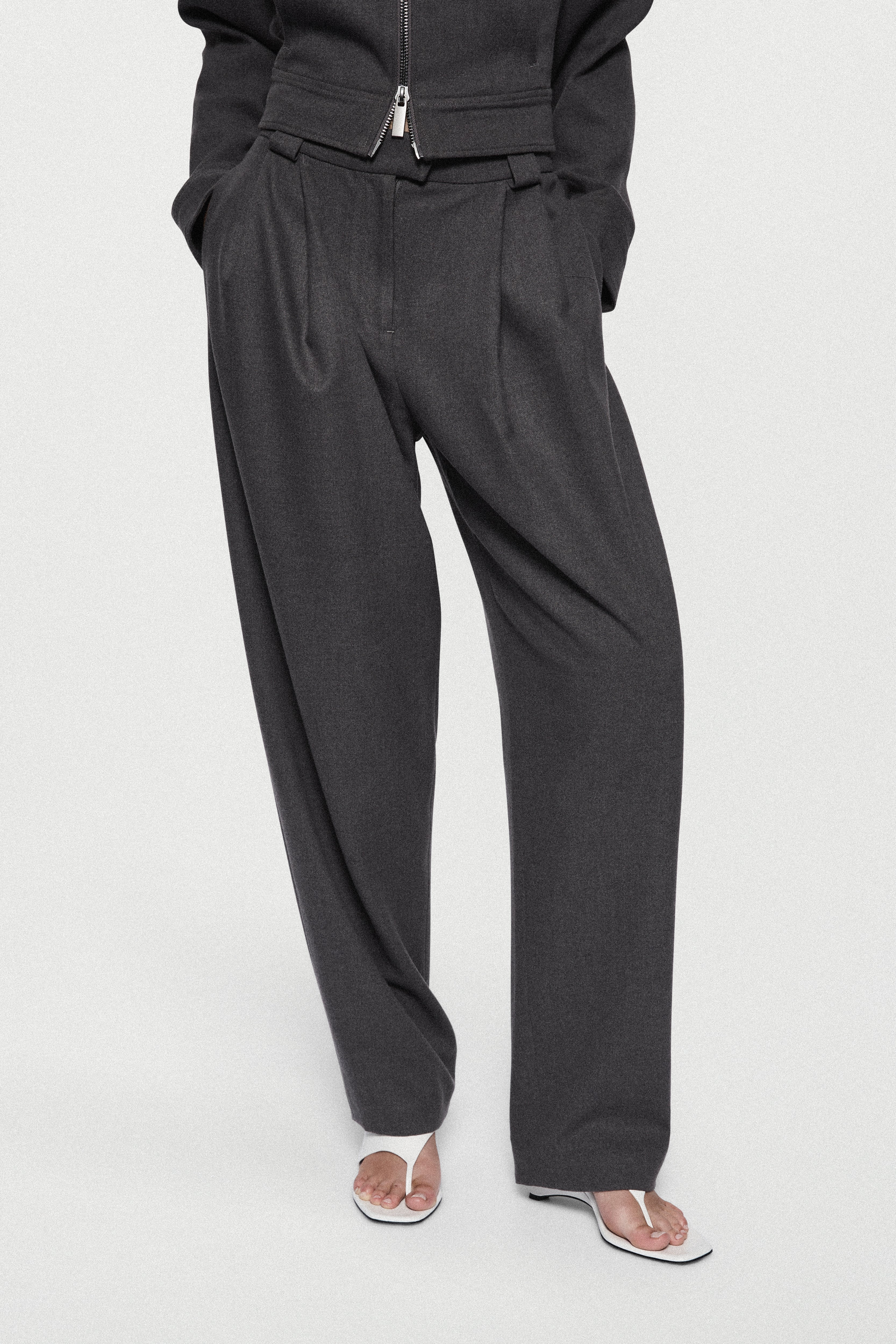 Charcoal tailored trousers with zip fly, pleated front, and tapered leg