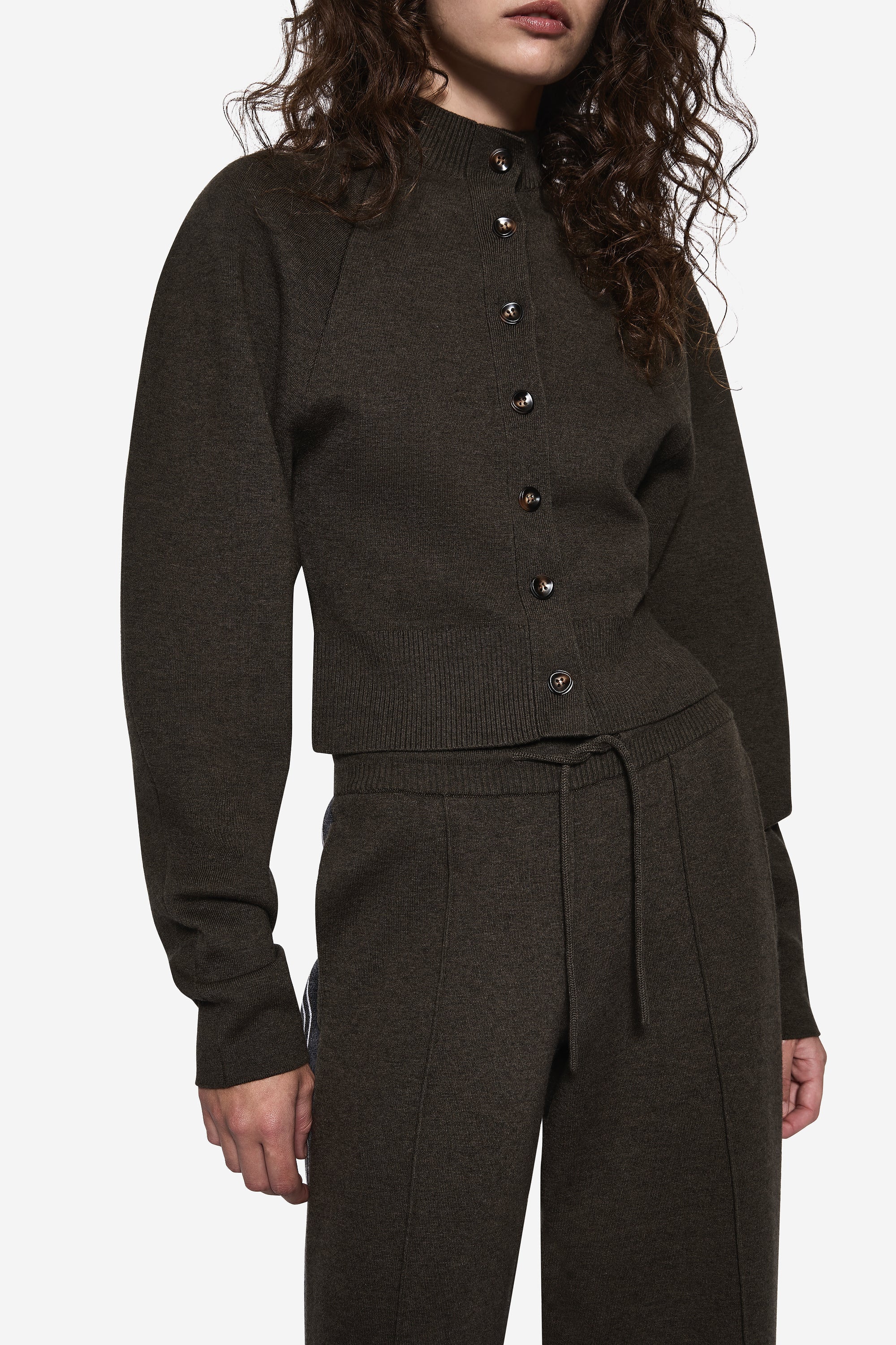 Hunter green knit cardigan close-up, button placket and ribbed hem