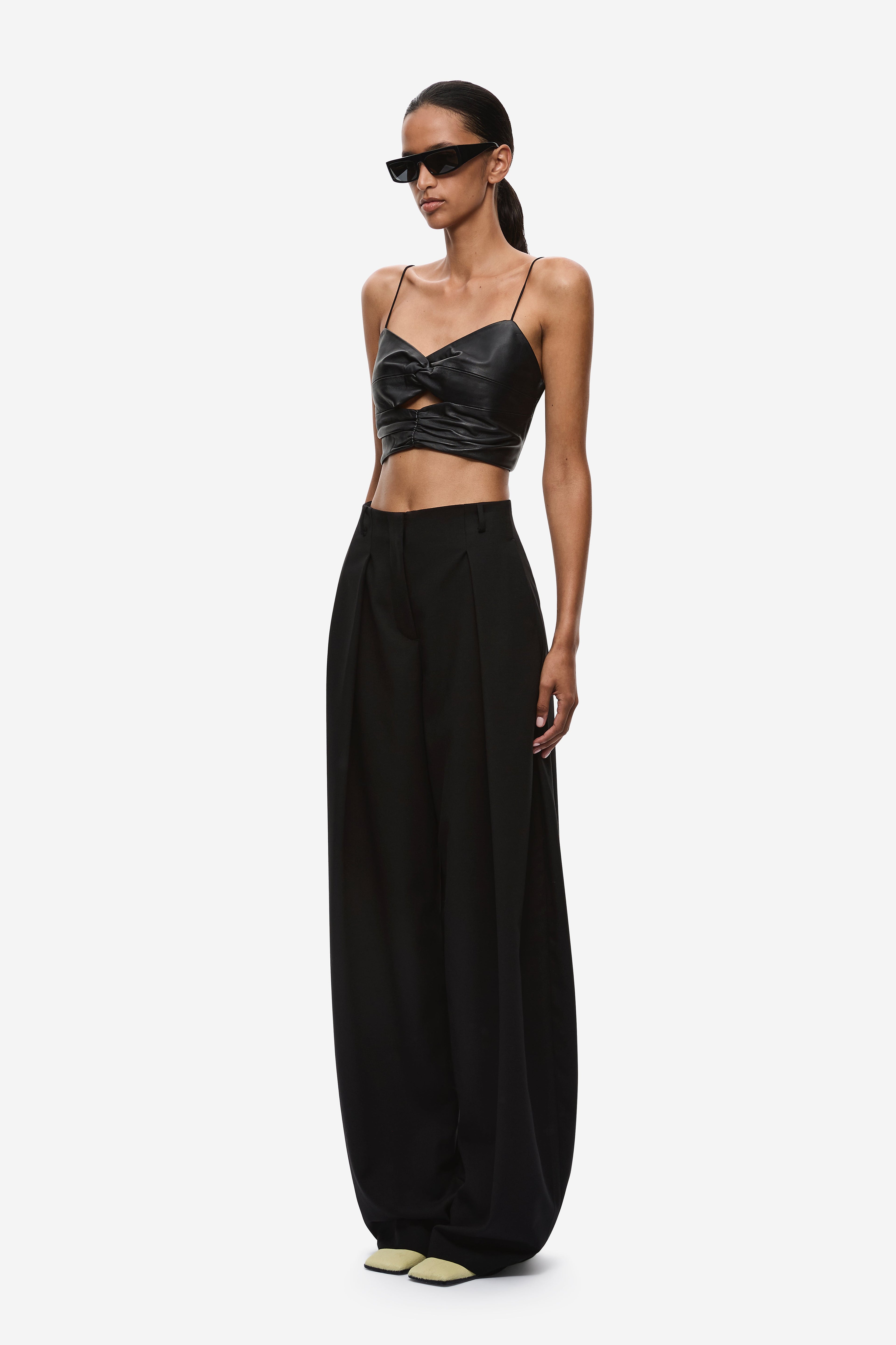 Black wide-leg trousers, side view, high waist and pleated front