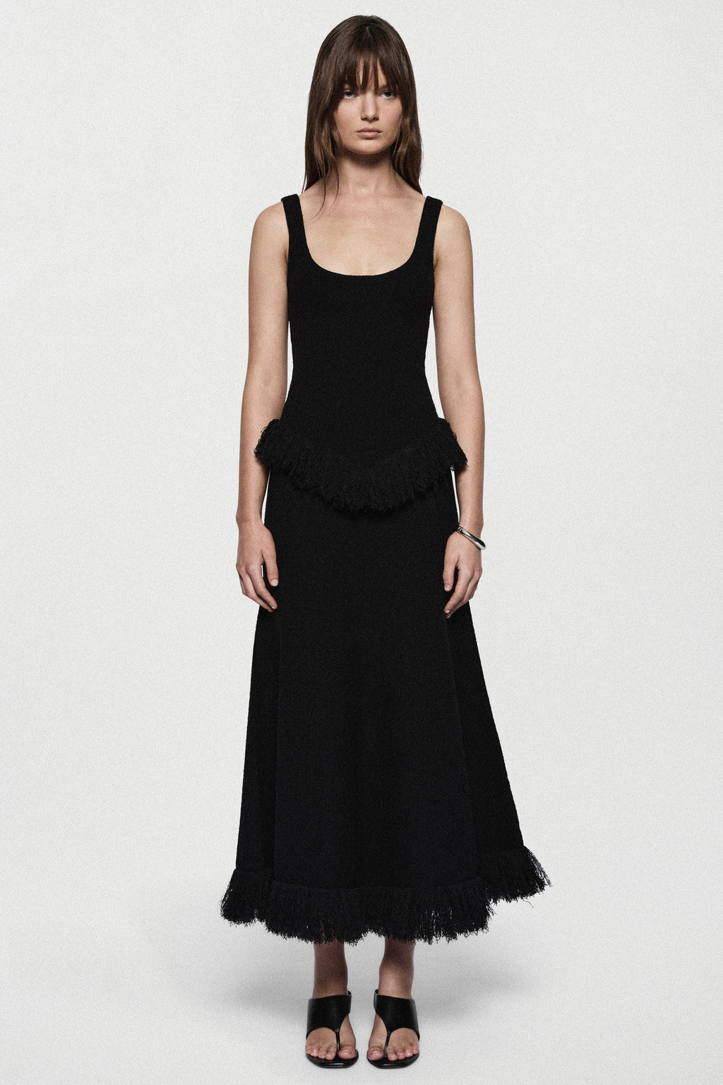 Black sleeveless top with square neckline and layered fringe hem