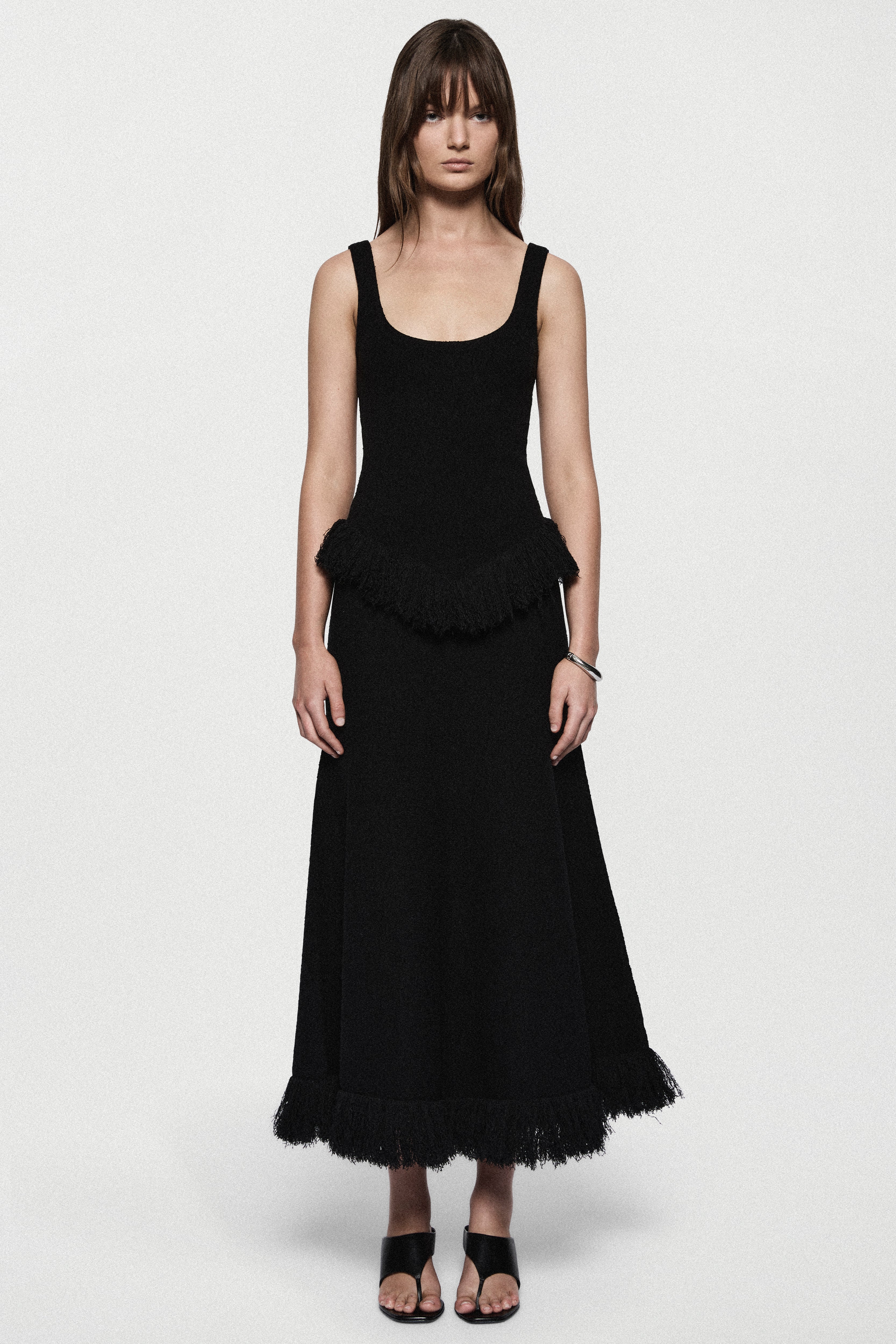 Black sleeveless top with square neckline and layered fringe hem