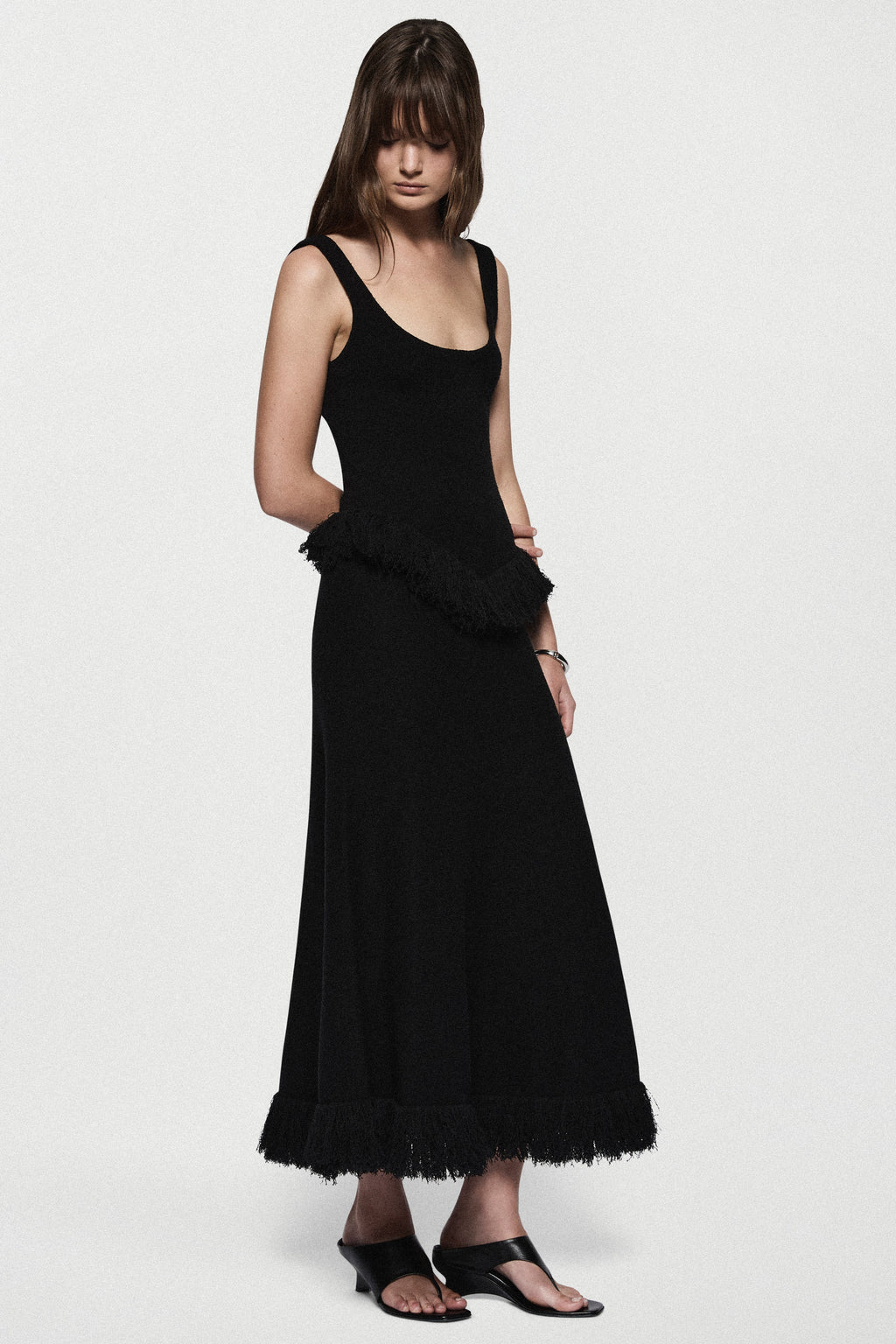 Black sleeveless square-neck top with uneven fringe hem overlay
