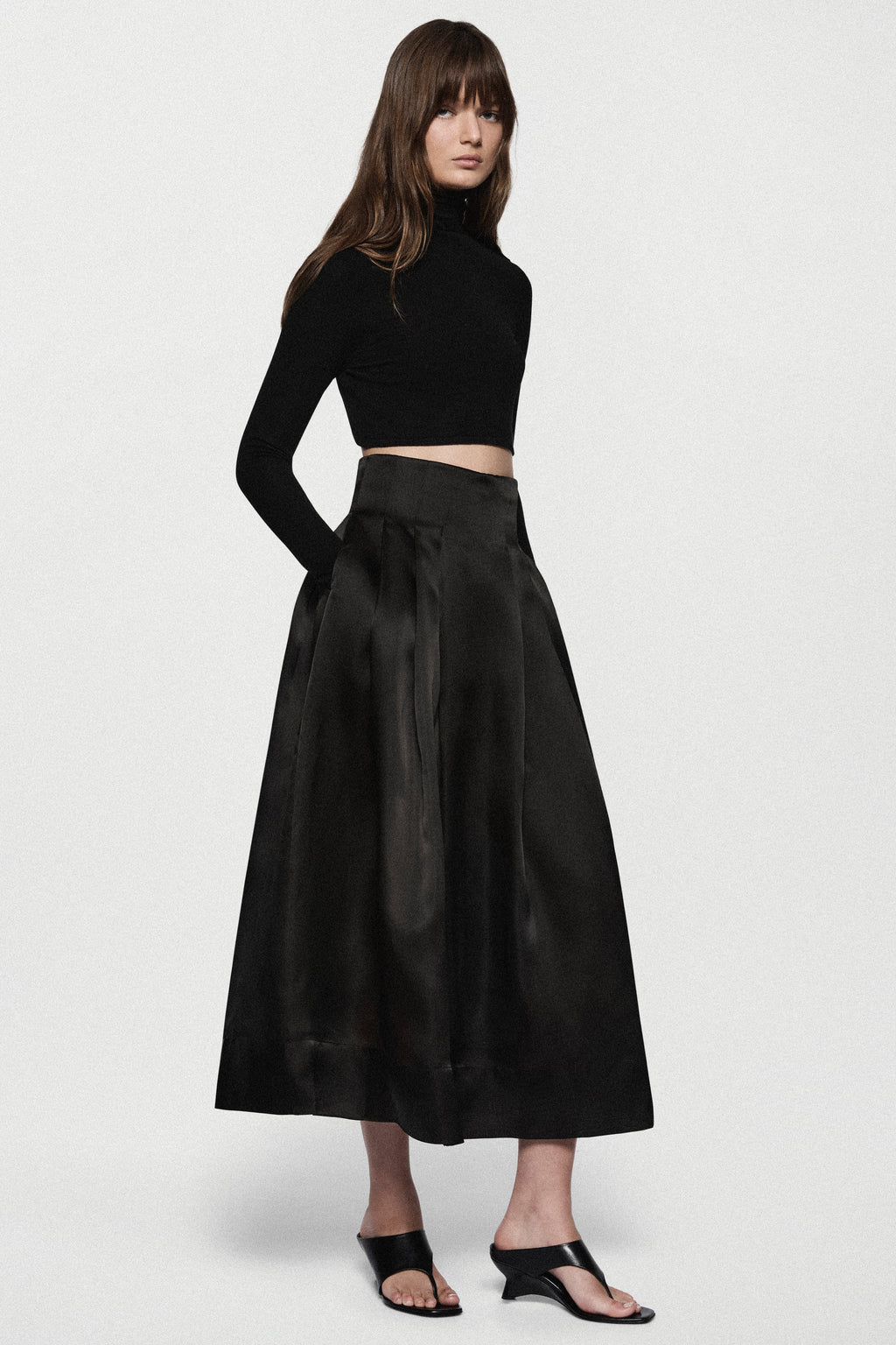 Black organza midi skirt with pleated A-line silhouette and elastic waistband