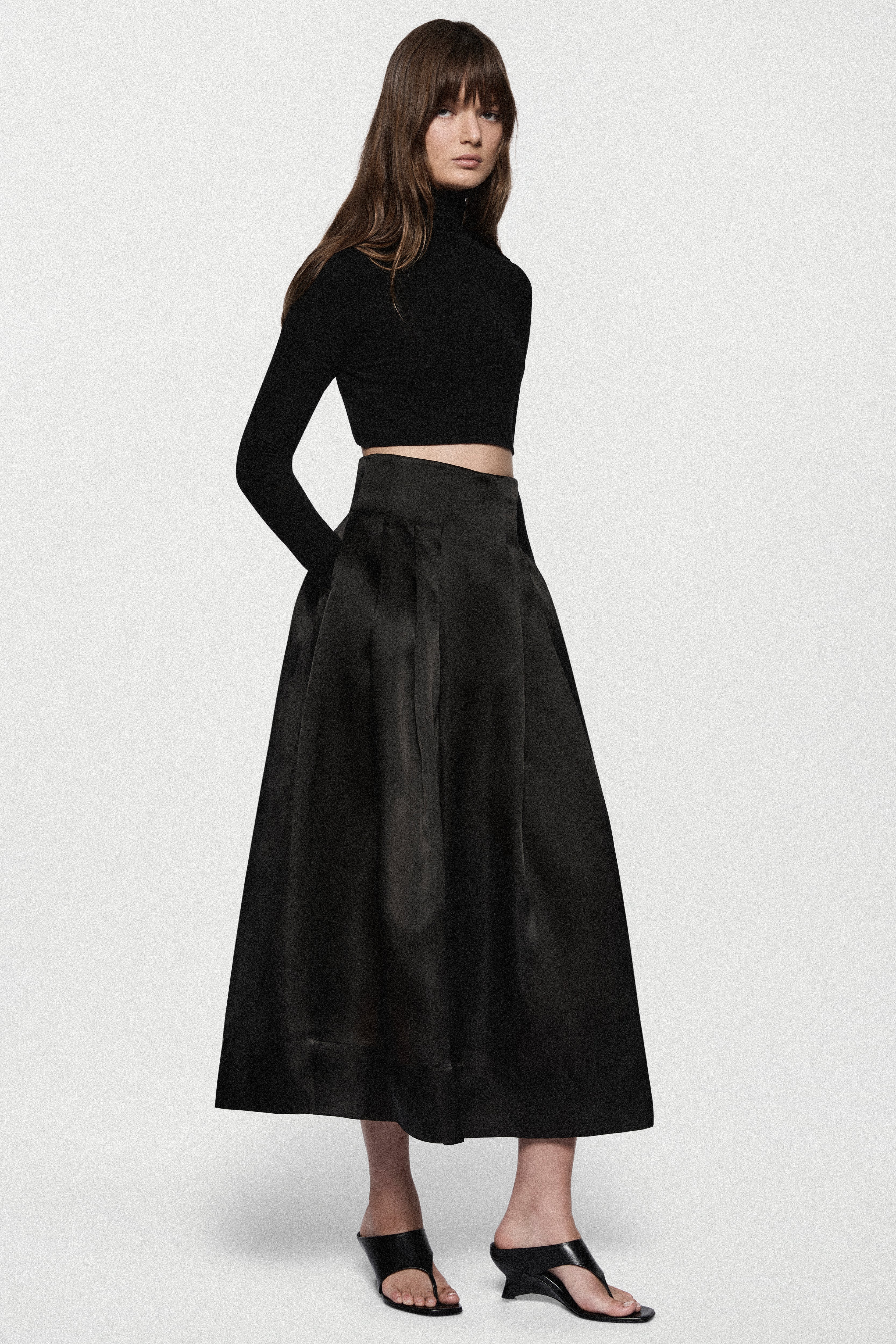 Black organza midi skirt with pleated A-line silhouette and elastic waistband