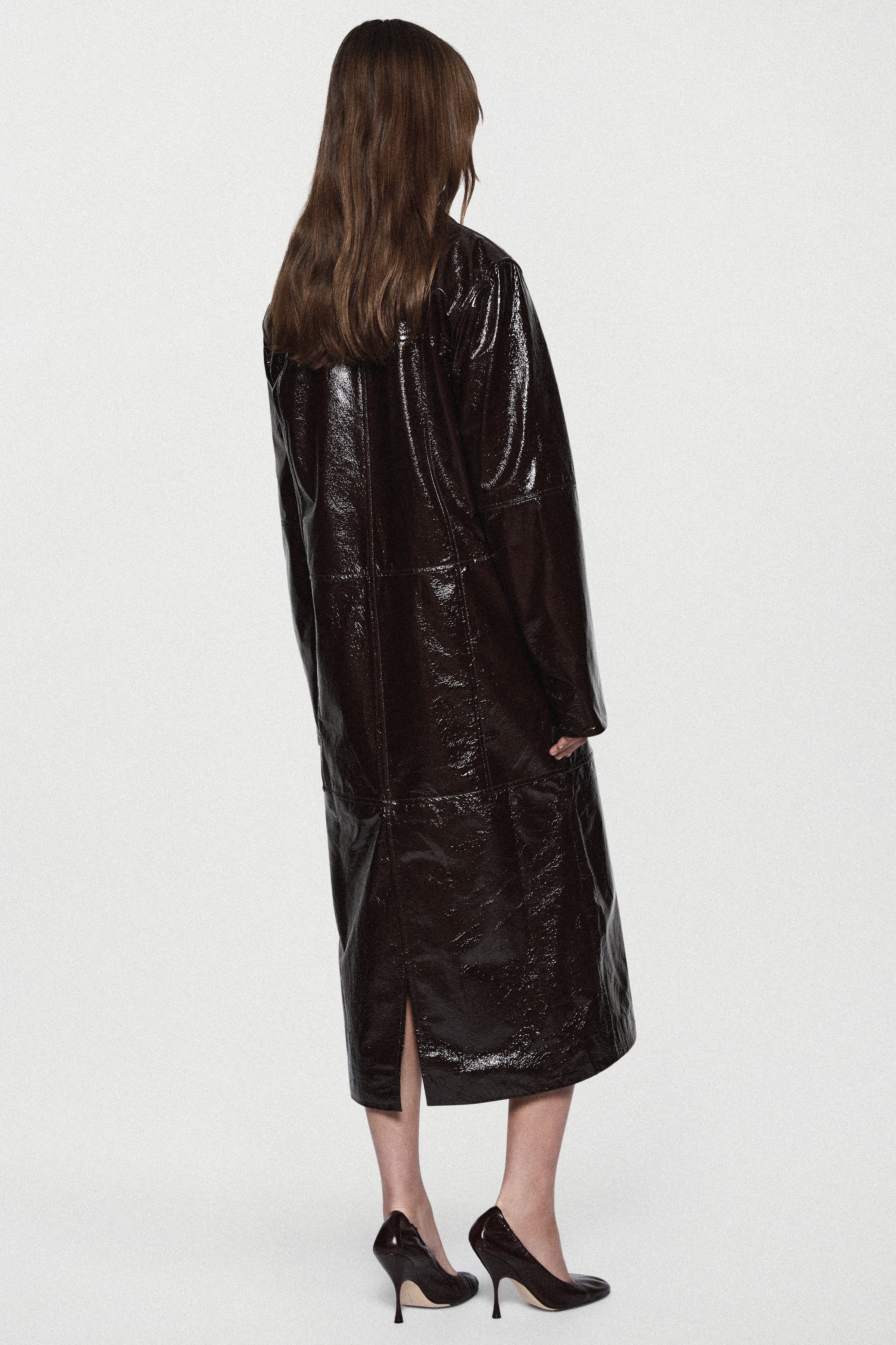 Bitter chocolate patent leather coat, glossy finish, back view with center hem slit