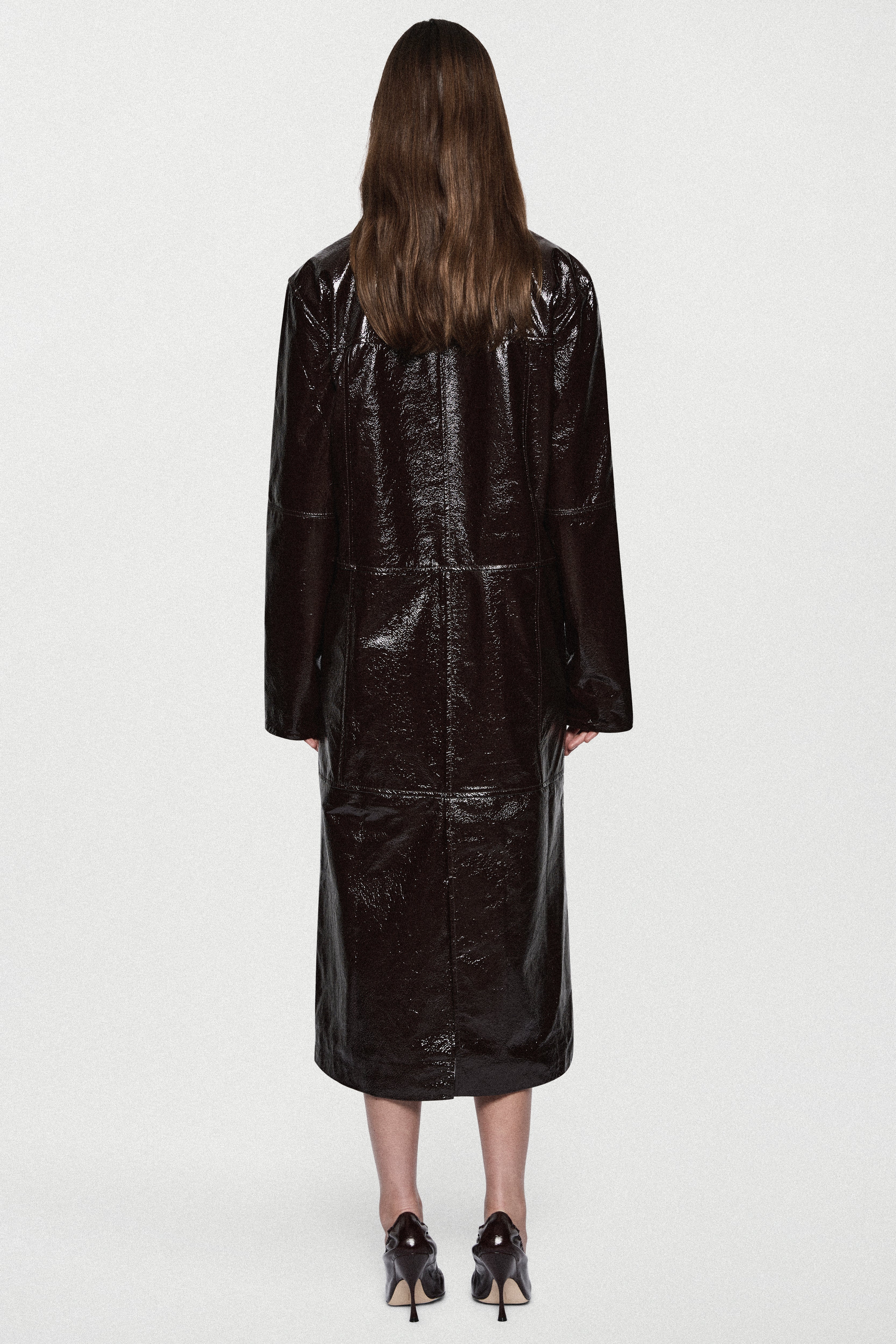 Back view of bitter chocolate patent leather coat, long glossy finish, button details
