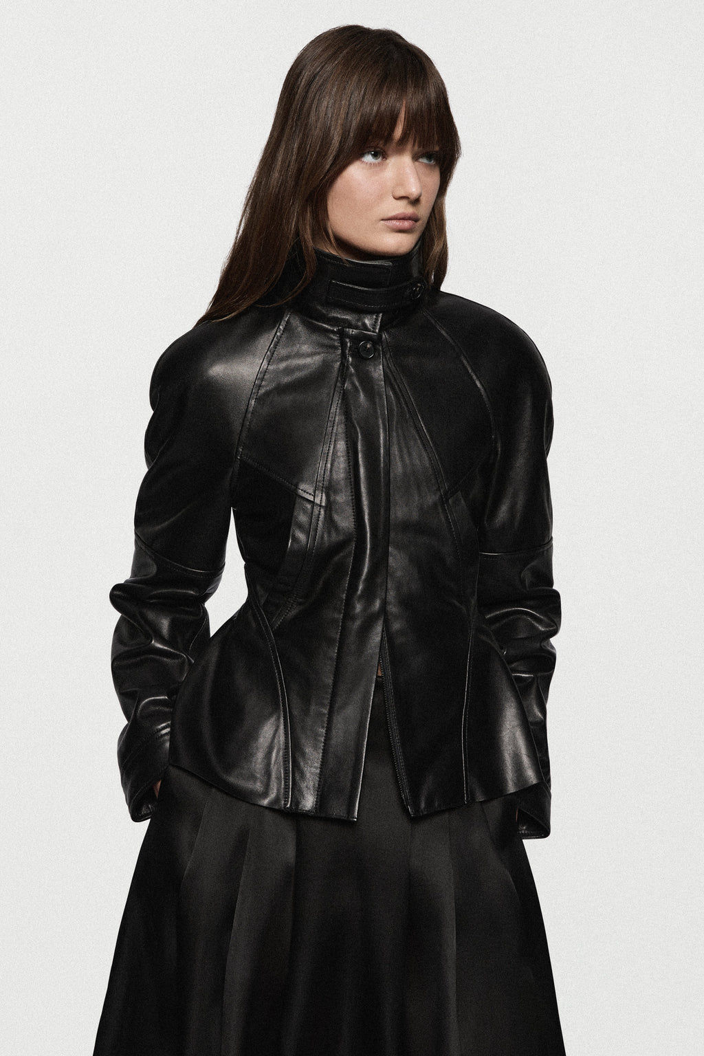 Black leather jacket with stand collar, front zip, and peplum waist detail.