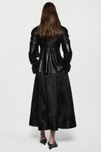 Black leather jacket back view with stand collar, central seam, and flared peplum hem.