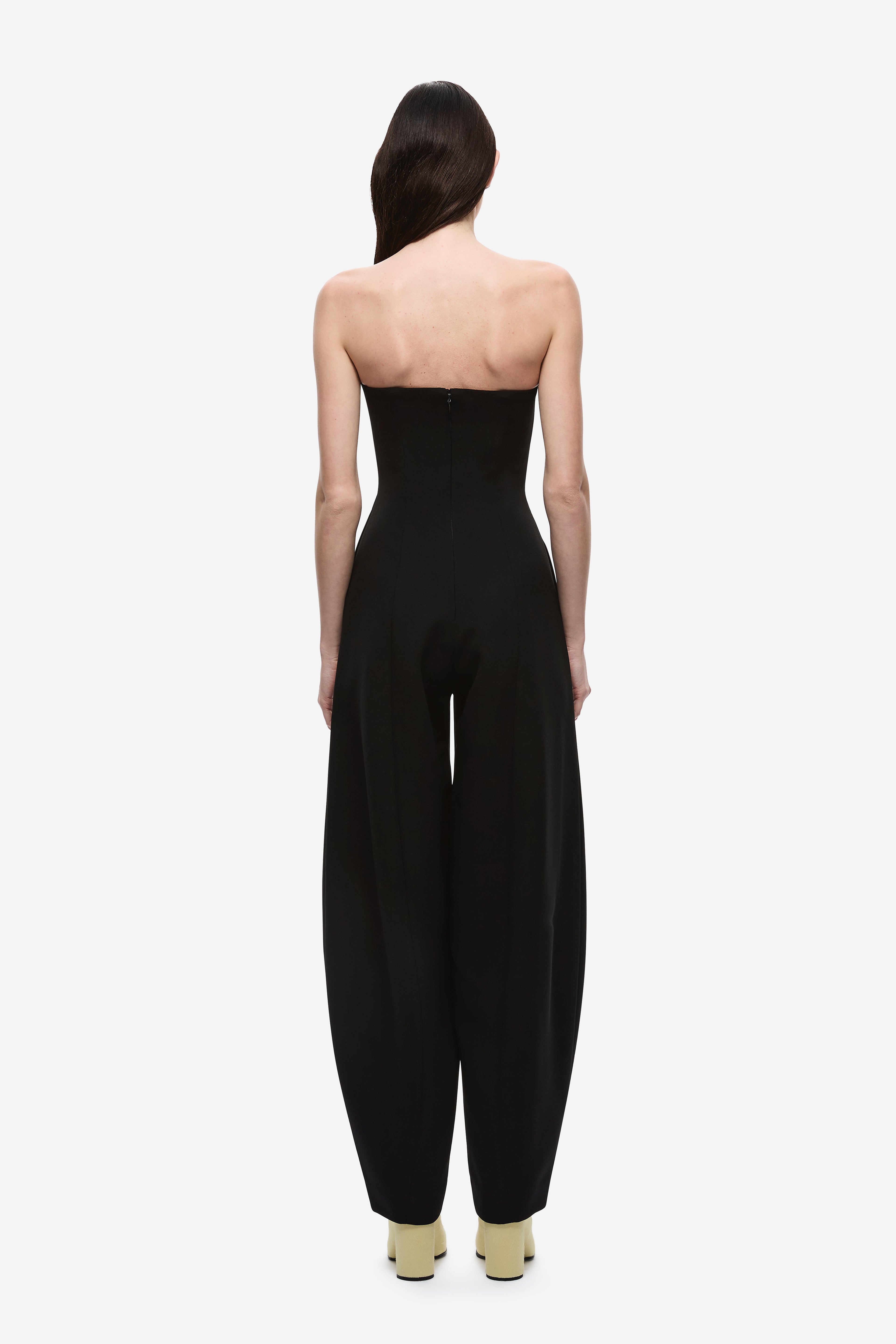 Black strapless jumpsuit, back view with long wide legs and center back seam