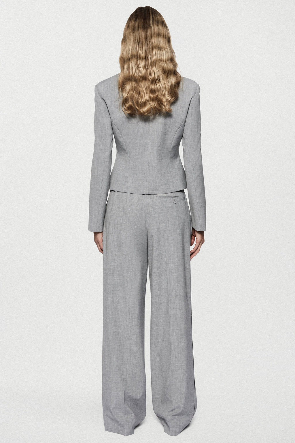 Grey tailored jacket back view with high neck, long sleeves, and waist seam detail.