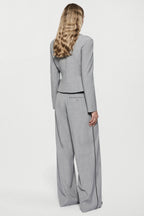 Grey tailored jacket back view with high neck, long sleeves, and curved hem.