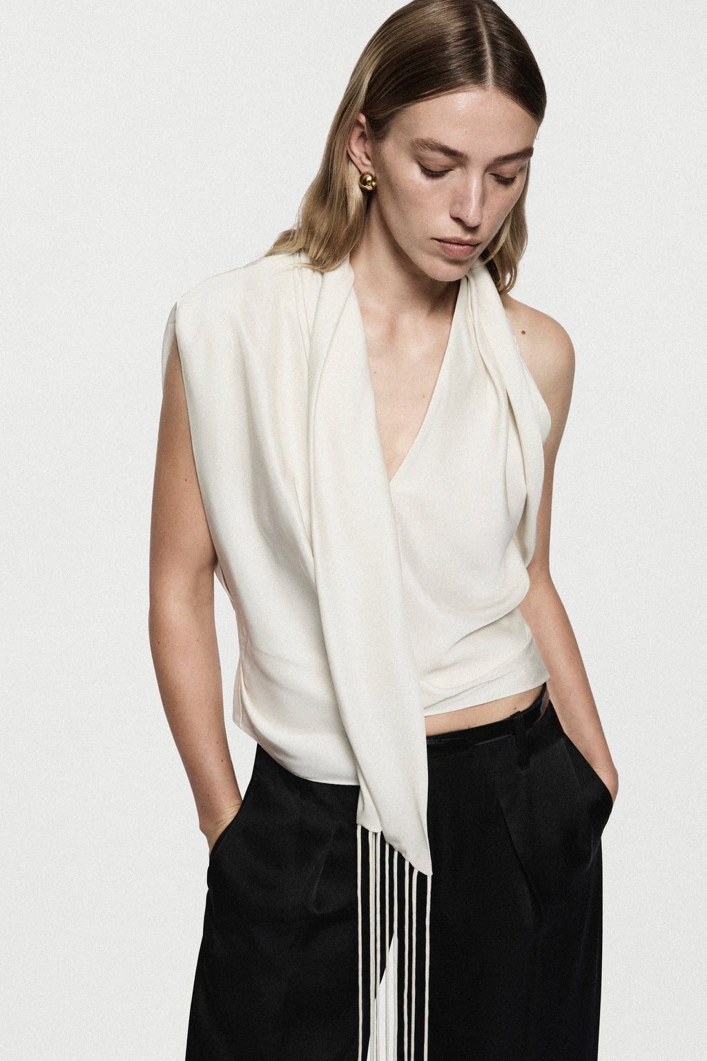 Winter white satin sleeveless drape top with V-neck and dangling vertical fringe