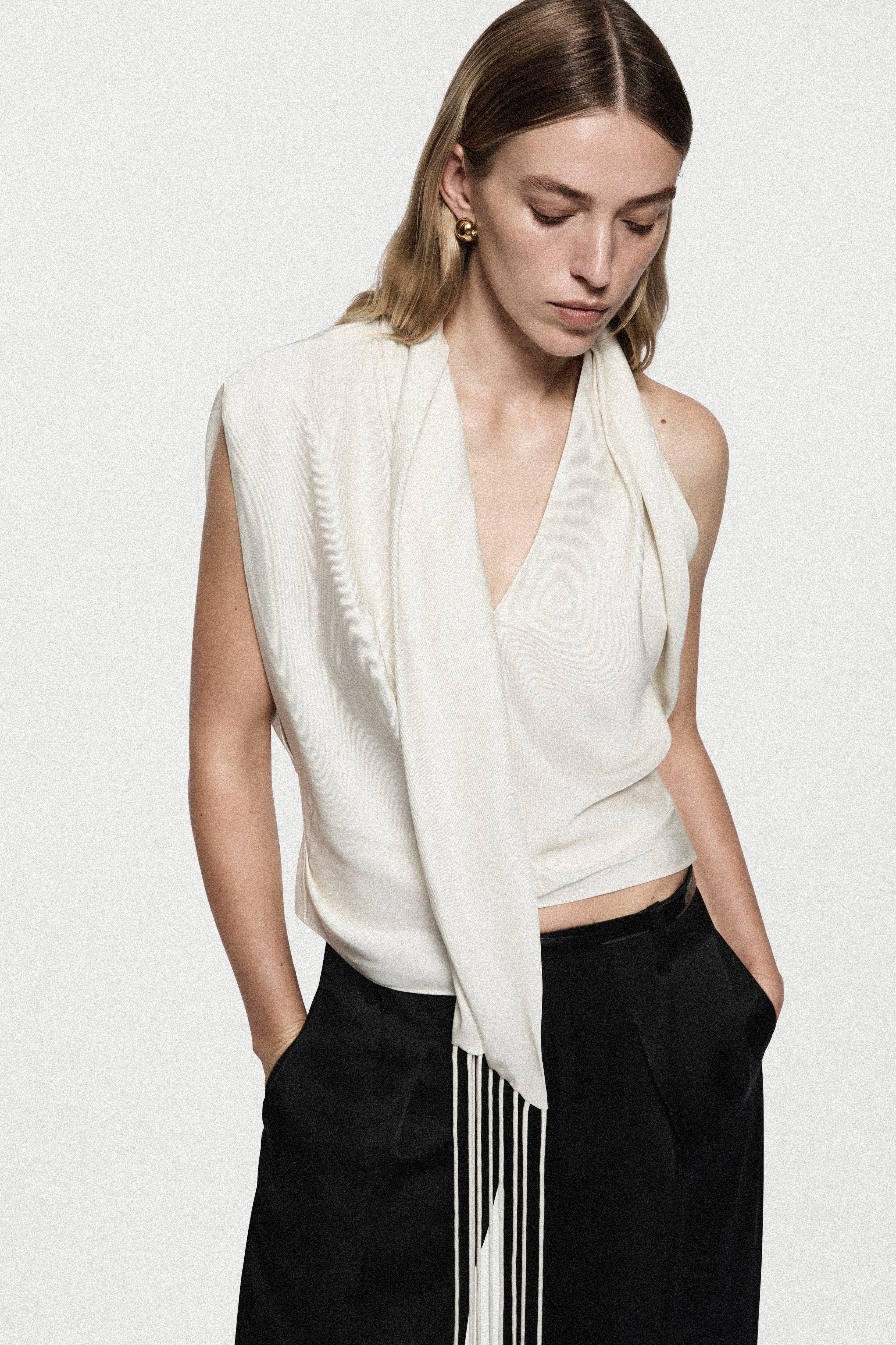 Winter white satin sleeveless drape top with V-neck and dangling vertical fringe