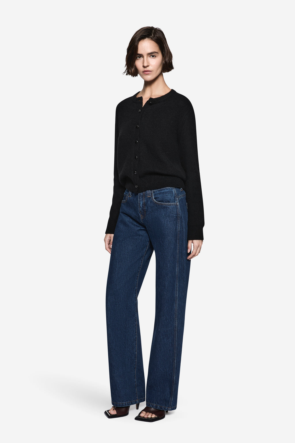 Black knit cardigan with four-button front and long sleeves, ribbed cuffs