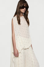 Close-up of winter white sleeveless rhinestone dot asymmetric top