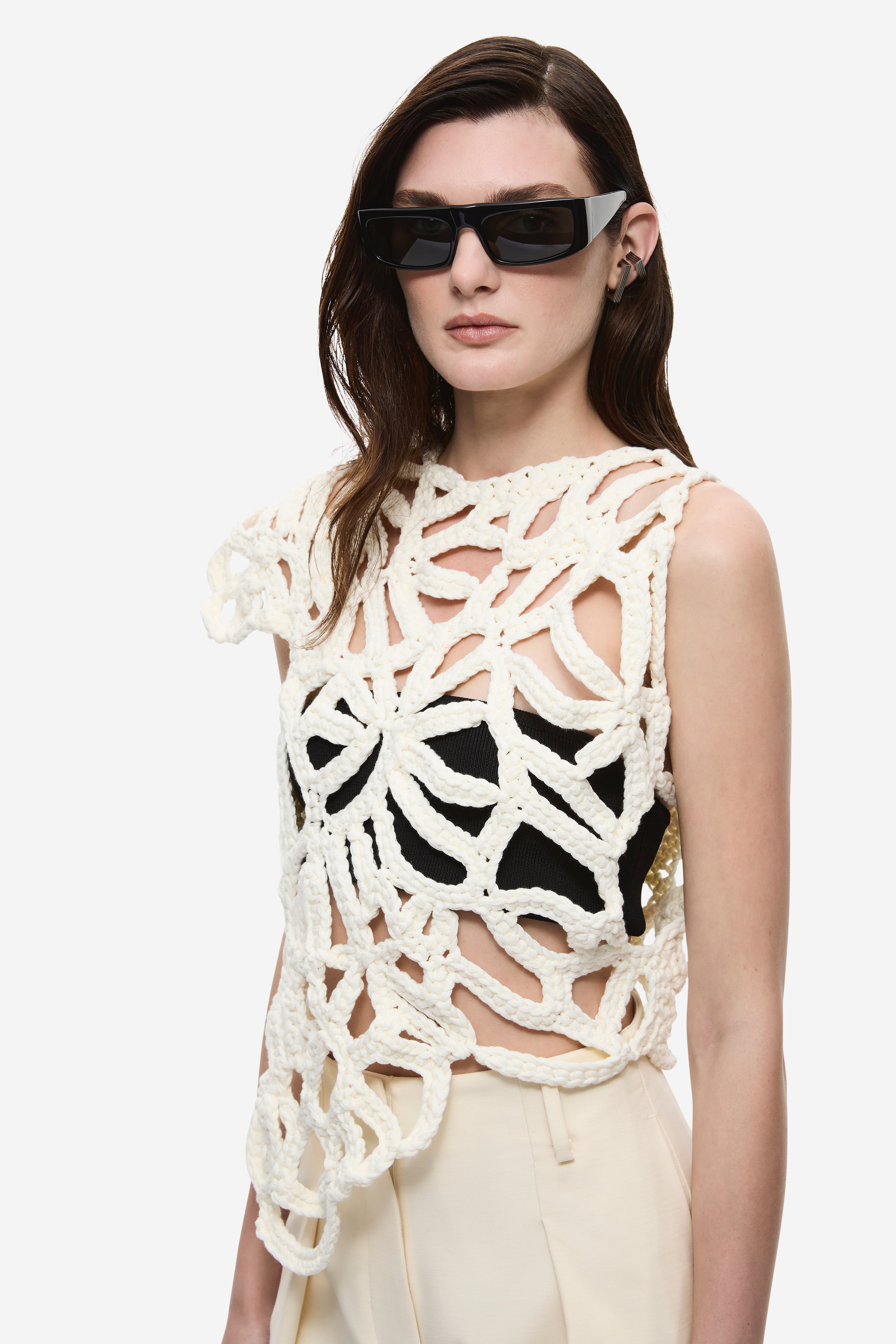 Ivory crochet top close-up with bold openwork loops and scalloped shoulder detail