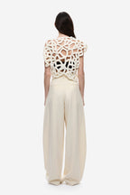 Ivory crochet top back view with openwork lace pattern and curved hem