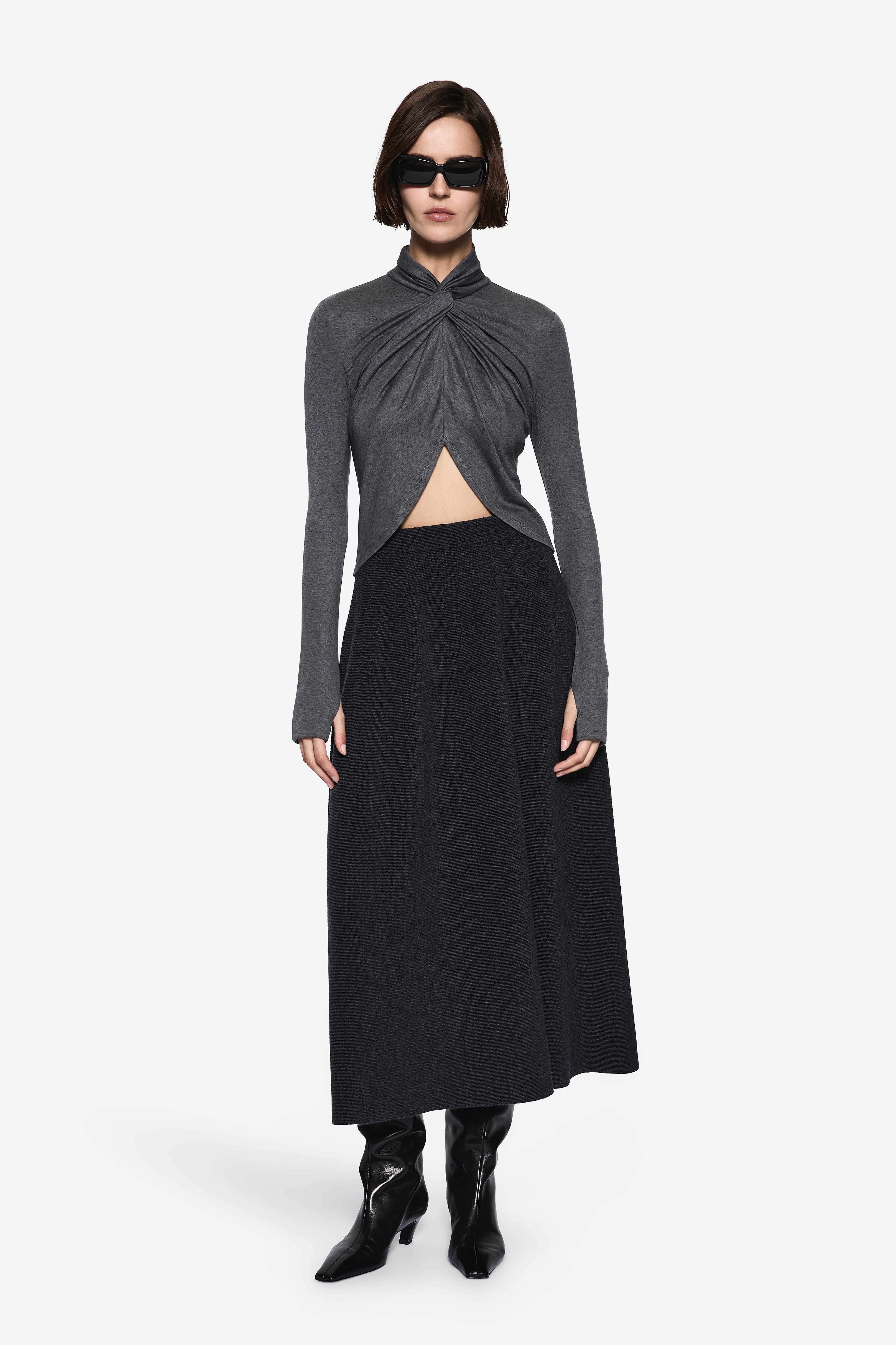 Dark charcoal TENCEL long-sleeve twist top with draped front and side slit.
