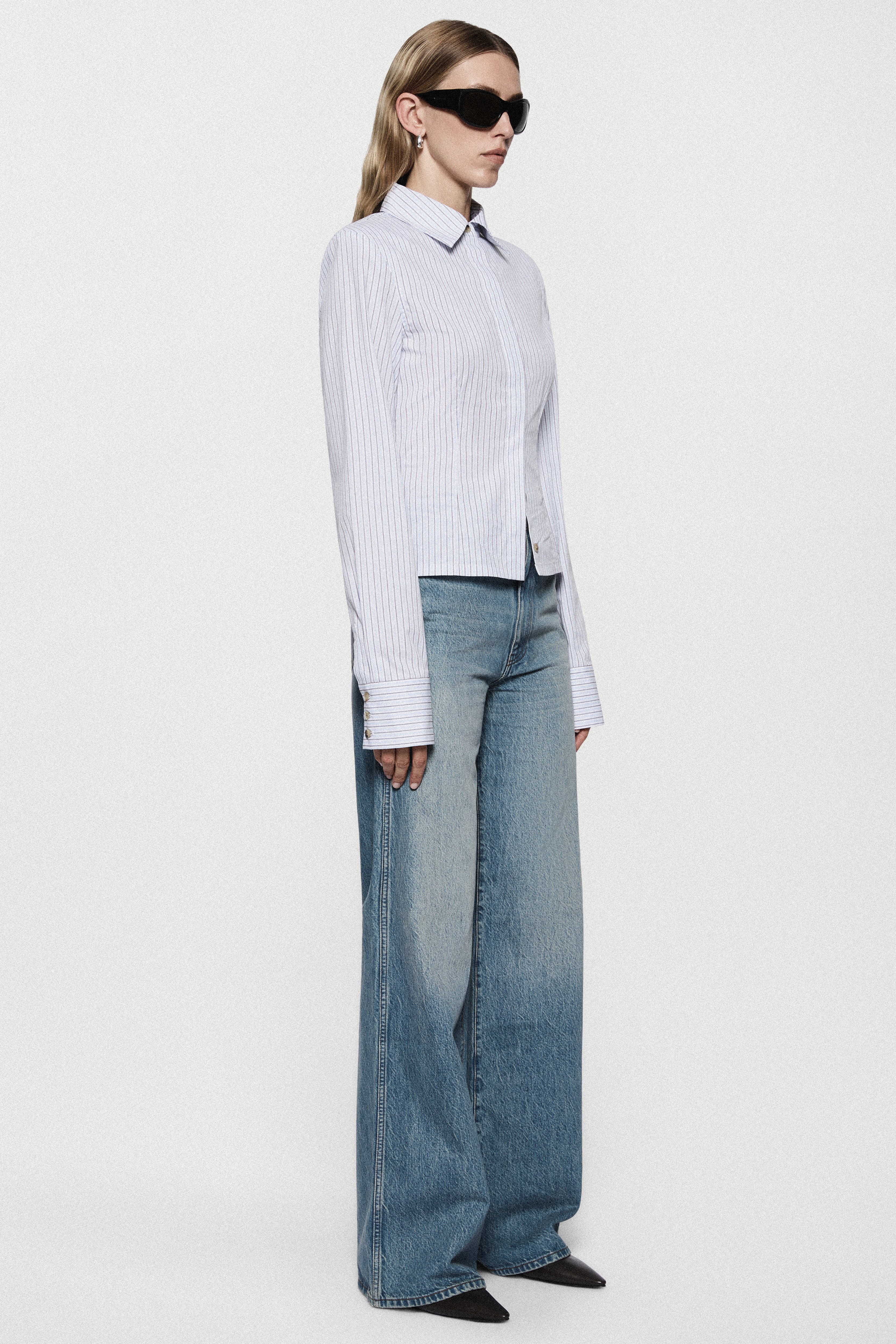 High-rise vintage wash wide-leg jeans side view, dark light-blue denim, flared hem