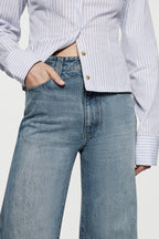High-rise vintage wash jeans close-up: faded denim waist with button and zip