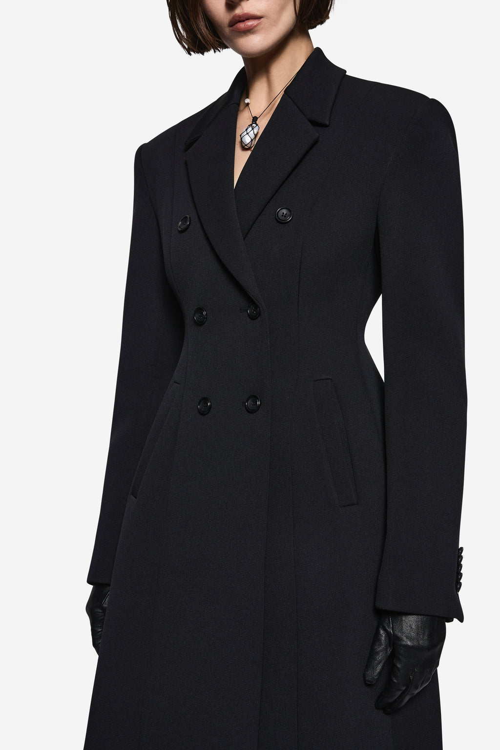 Black notch-collar coat close-up with double-breasted buttons and structured lapels