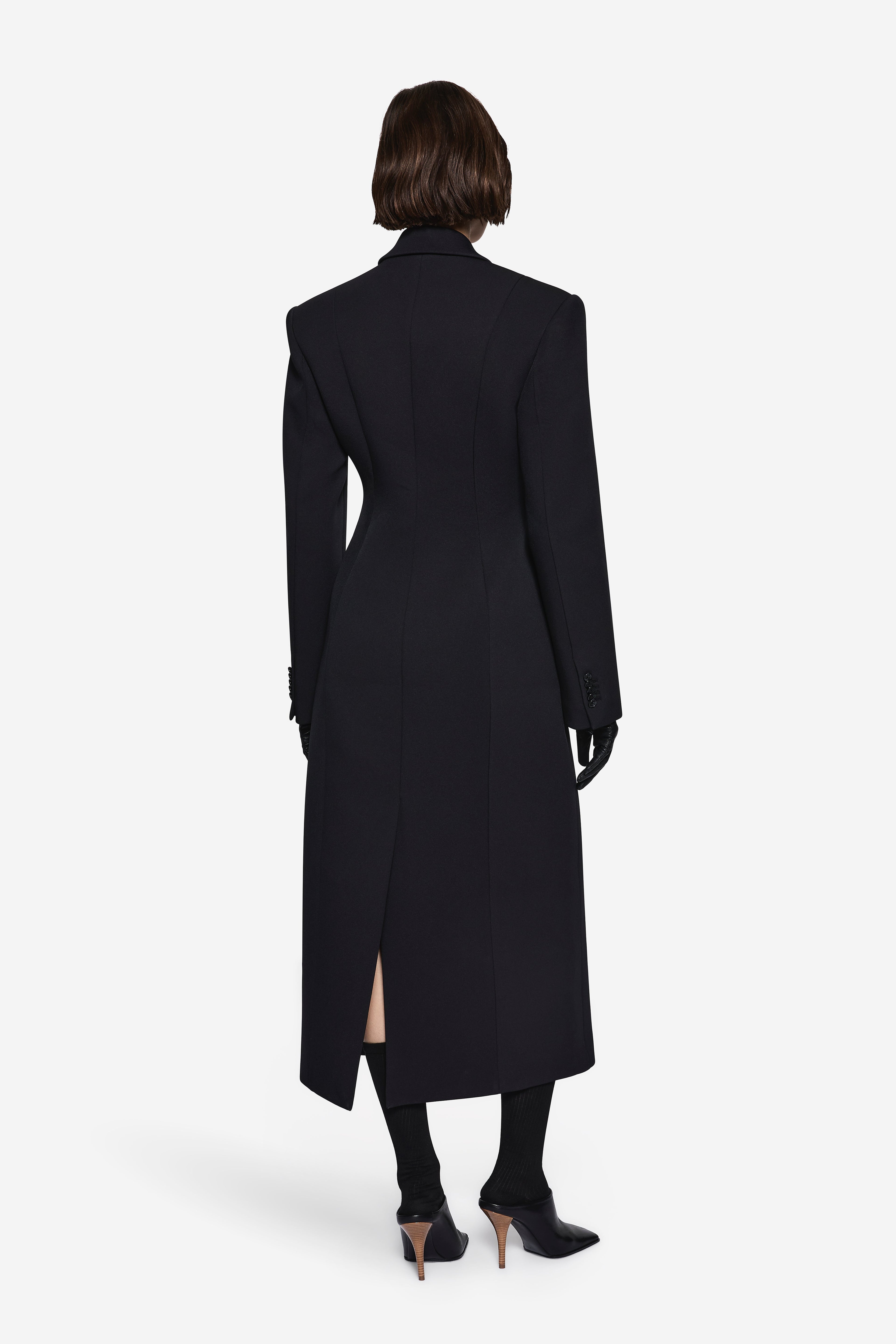 Black long notch-collar coat, back view with center seam and side slit hem