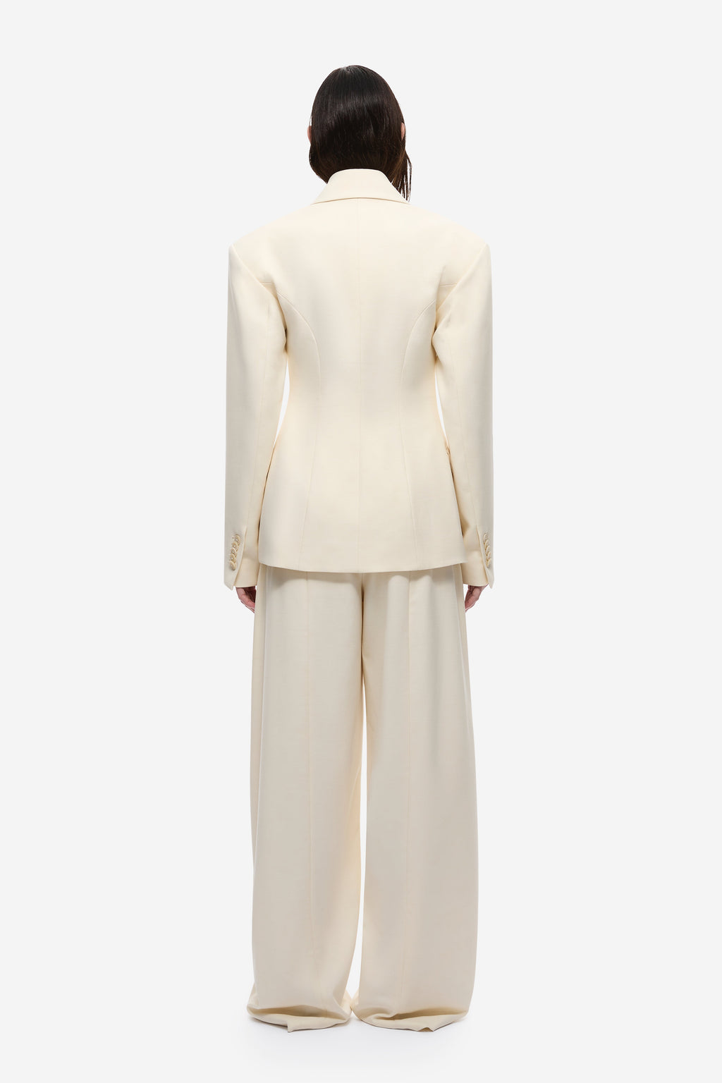 Cream blazer back view with yoke seam and long sleeves.