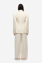 Cream blazer back view with yoke seam and long sleeves.