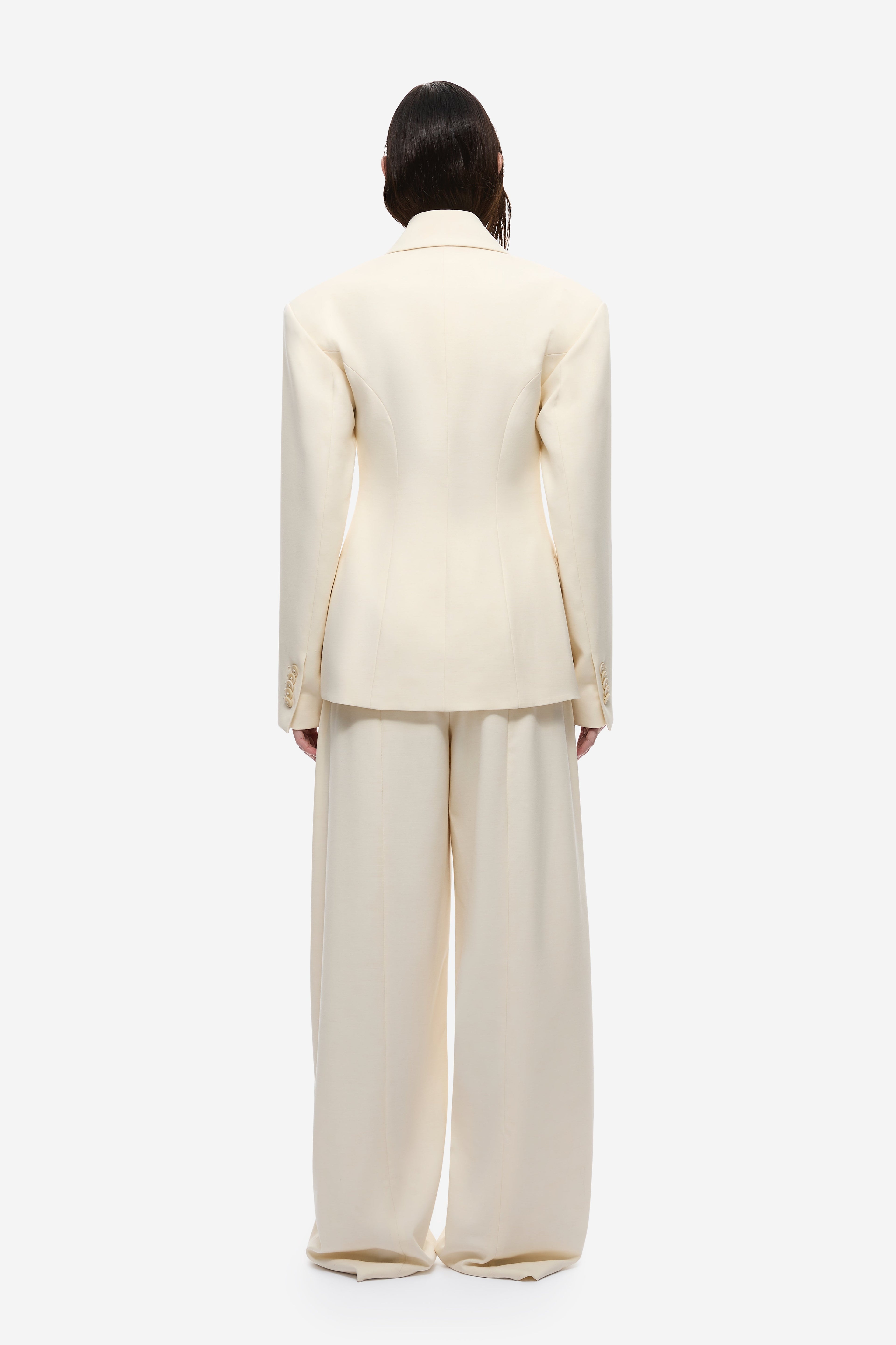 Cream blazer back view with yoke seam and long sleeves.