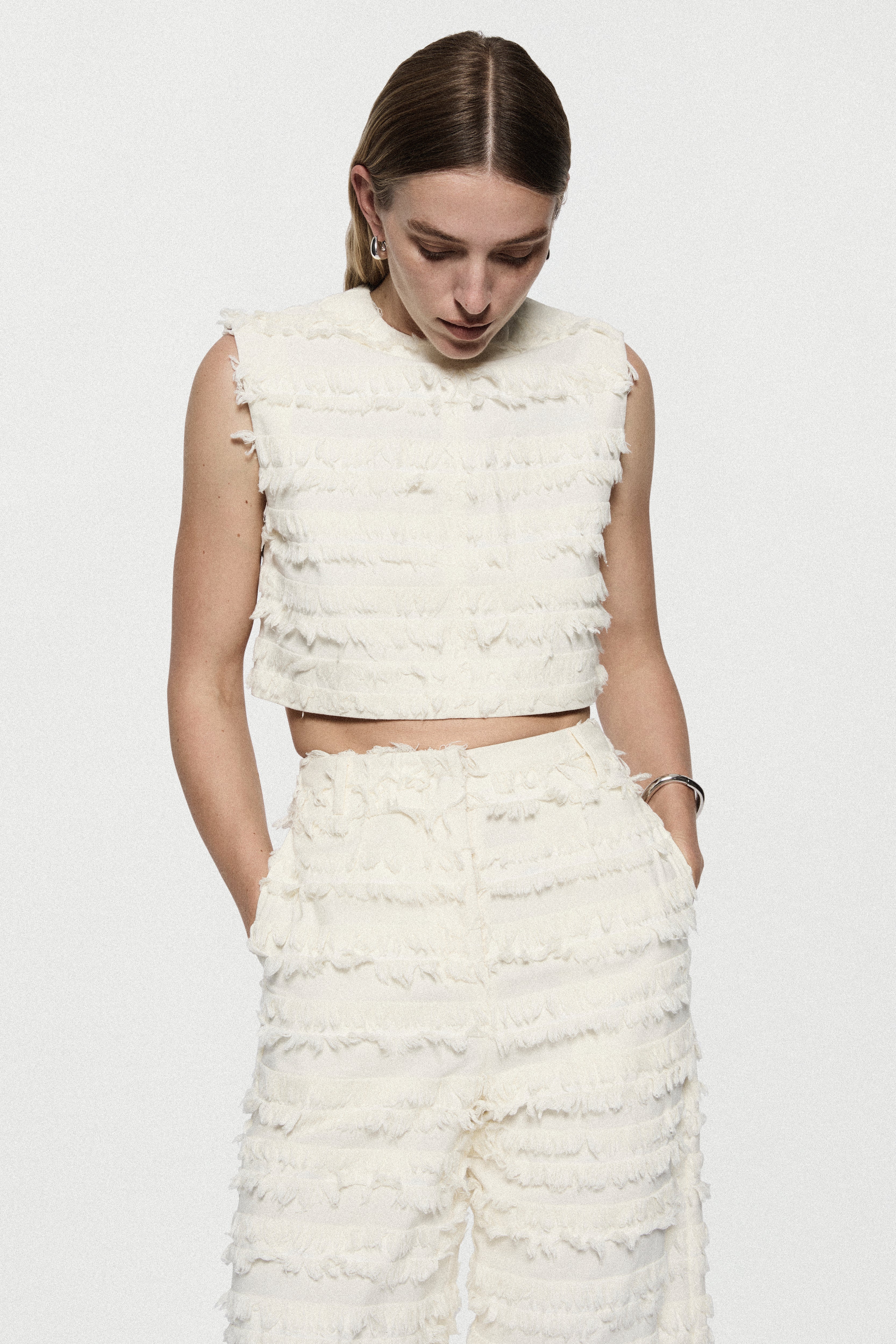 Off-white cotton fringe crop top, sleeveless with textured ruffled rows