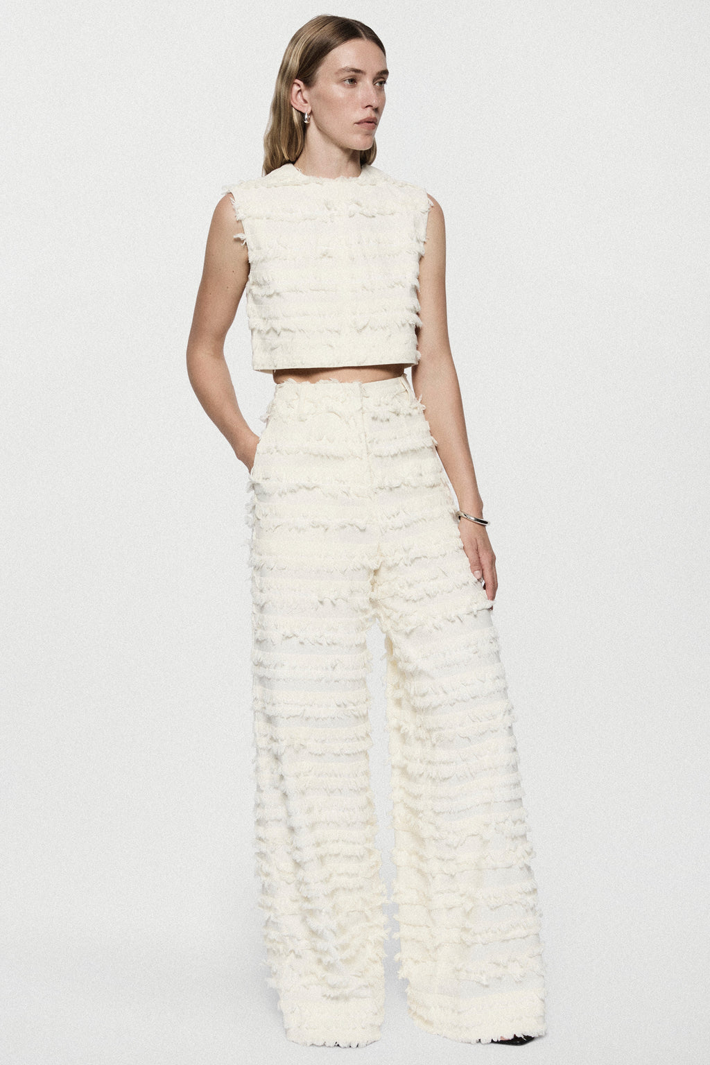 Winter white cotton fringe wide-leg pants with ruffled horizontal rows, side view