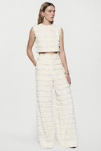 Off-white sleeveless fringe crop top with high neckline and textured ruffles
