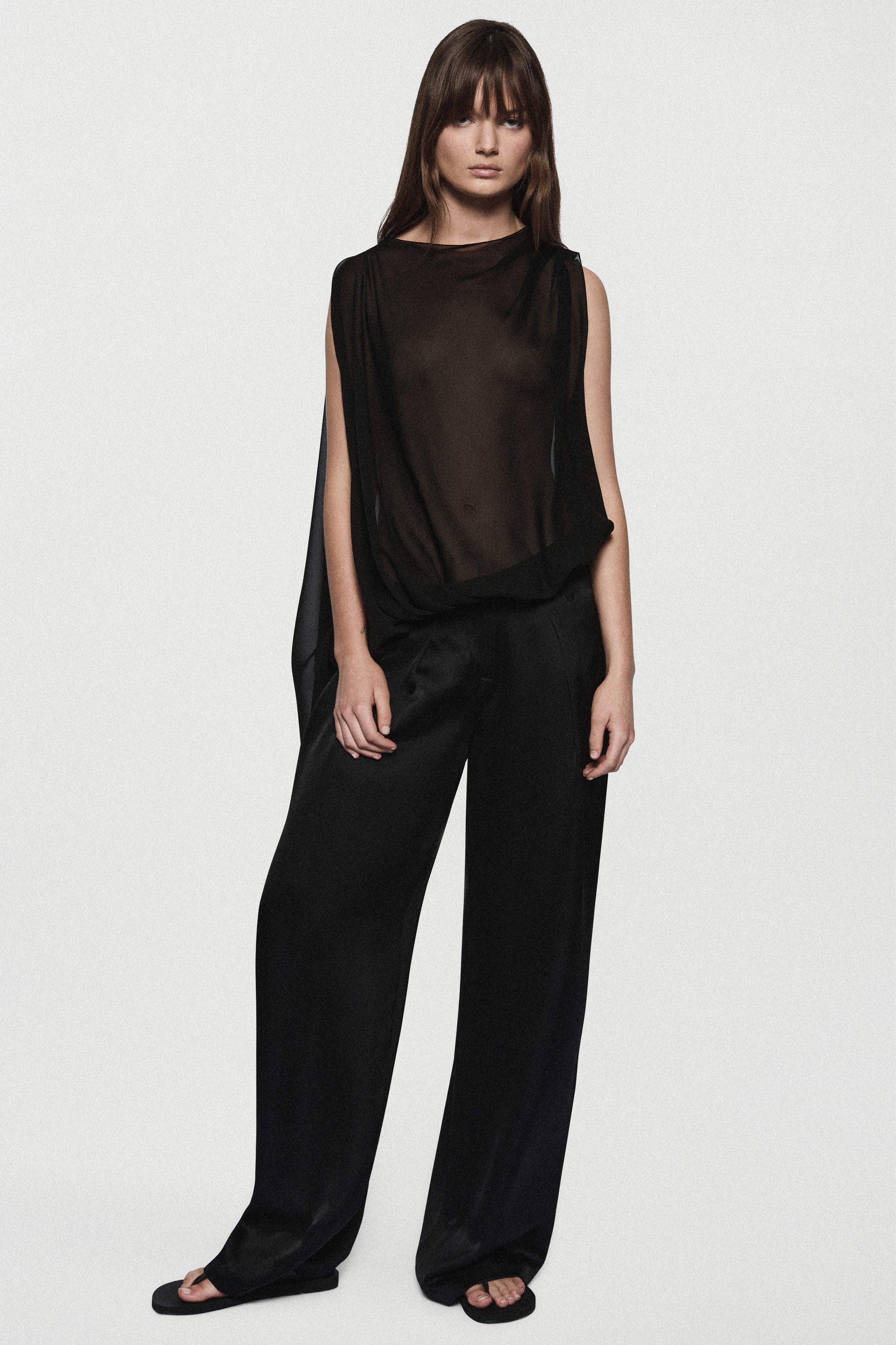 Black sheer sleeveless silk blouse with high neck and relaxed draped fit