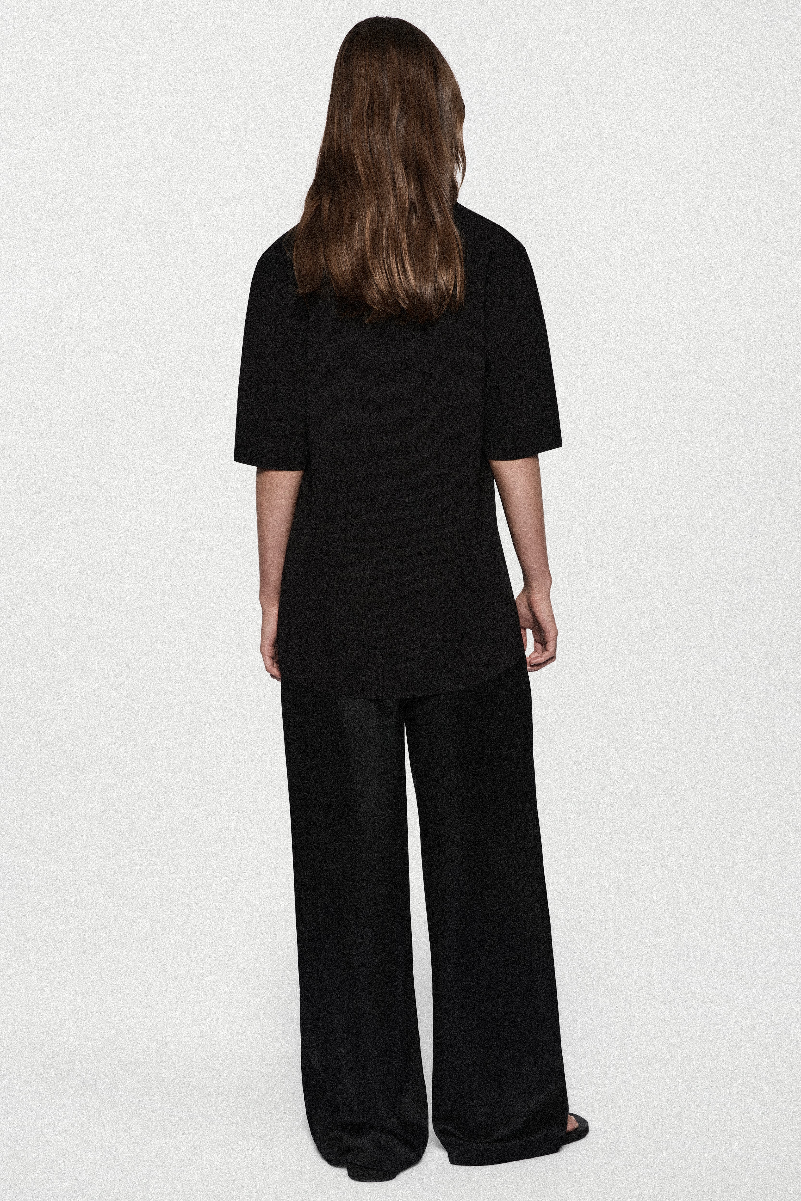 Black oversized knit tee, back view, short sleeves and crew neckline
