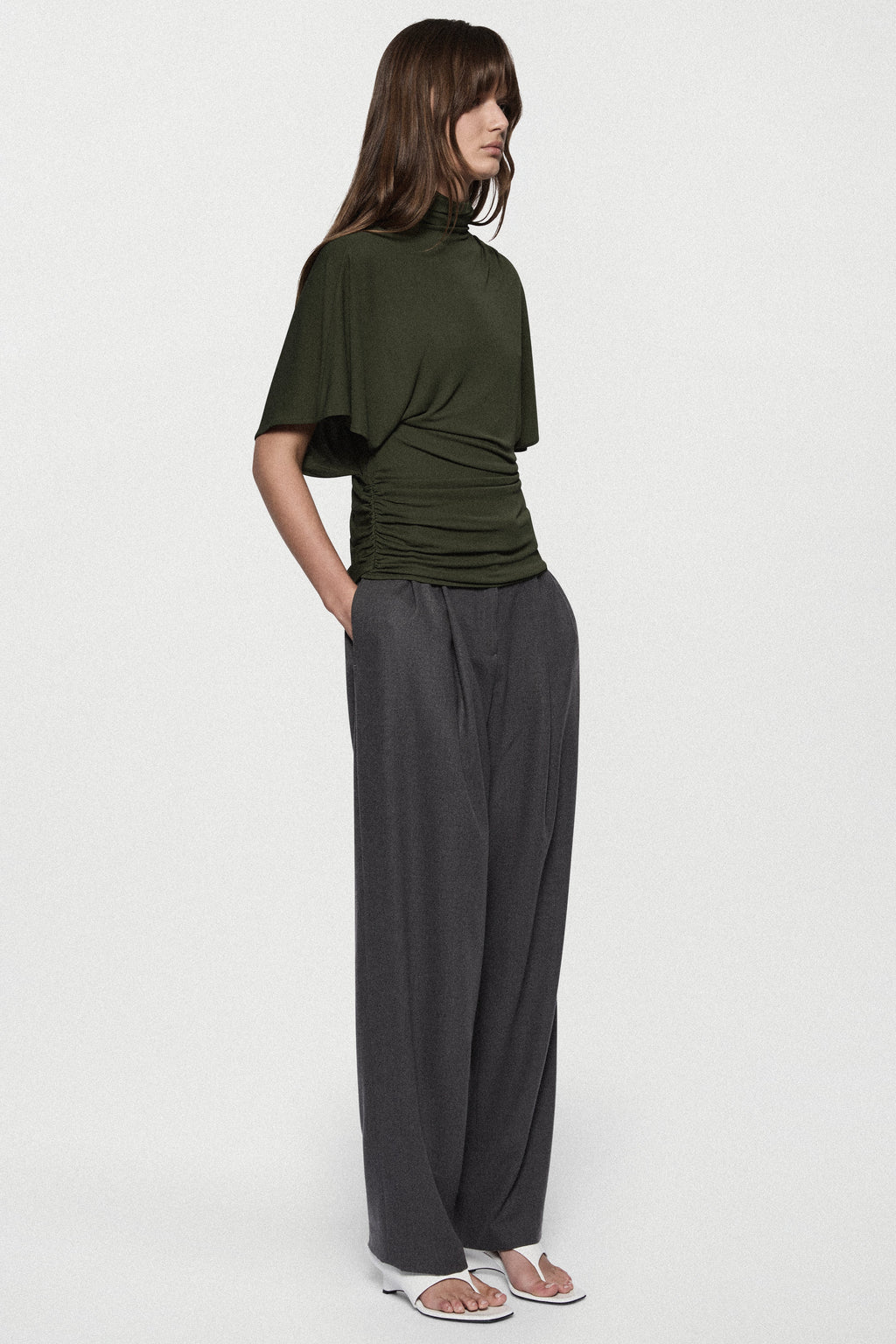Hunter green cape jersey turtleneck top with gathered front and loose short sleeves.