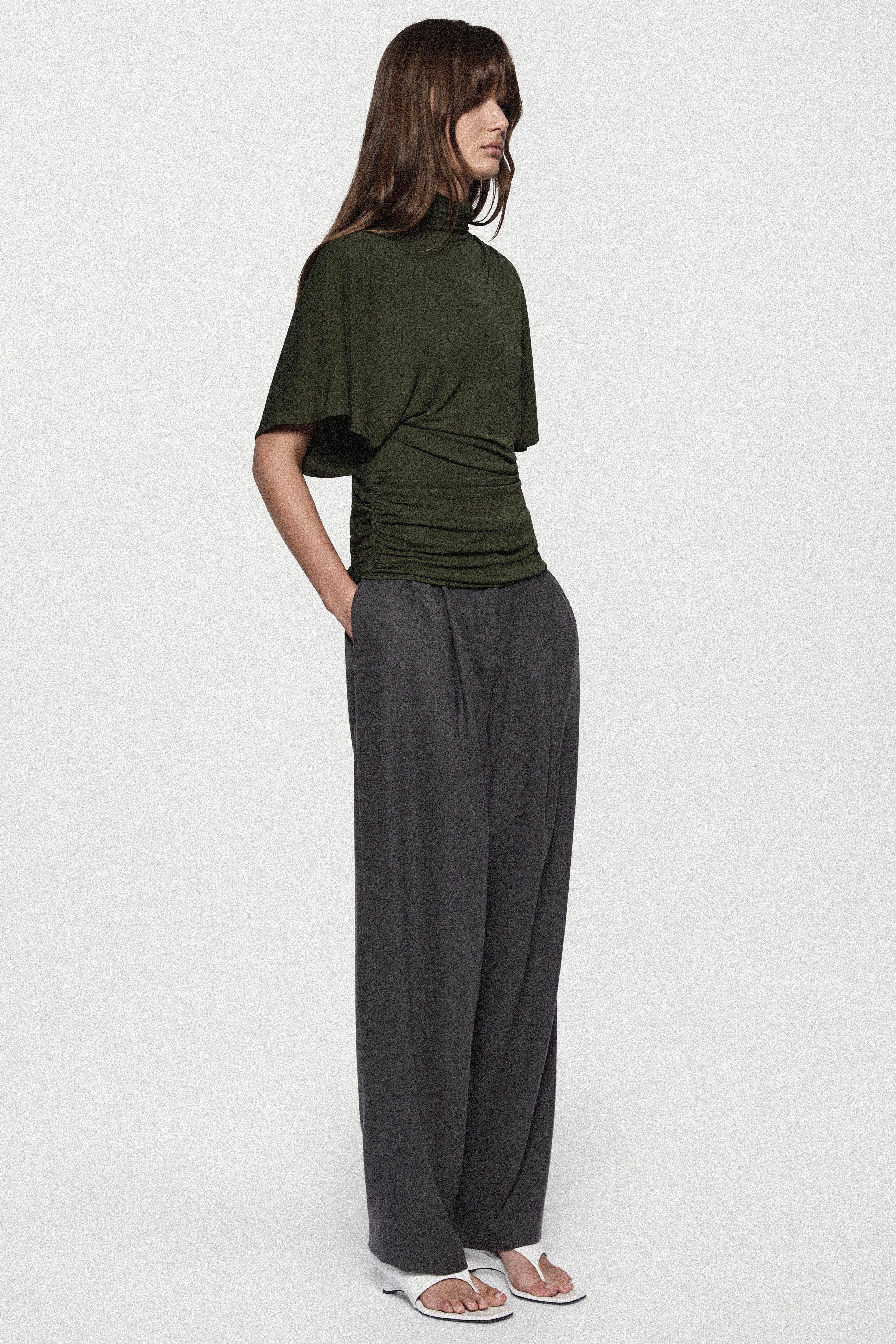 Hunter green cape jersey turtleneck top with gathered front and loose short sleeves.