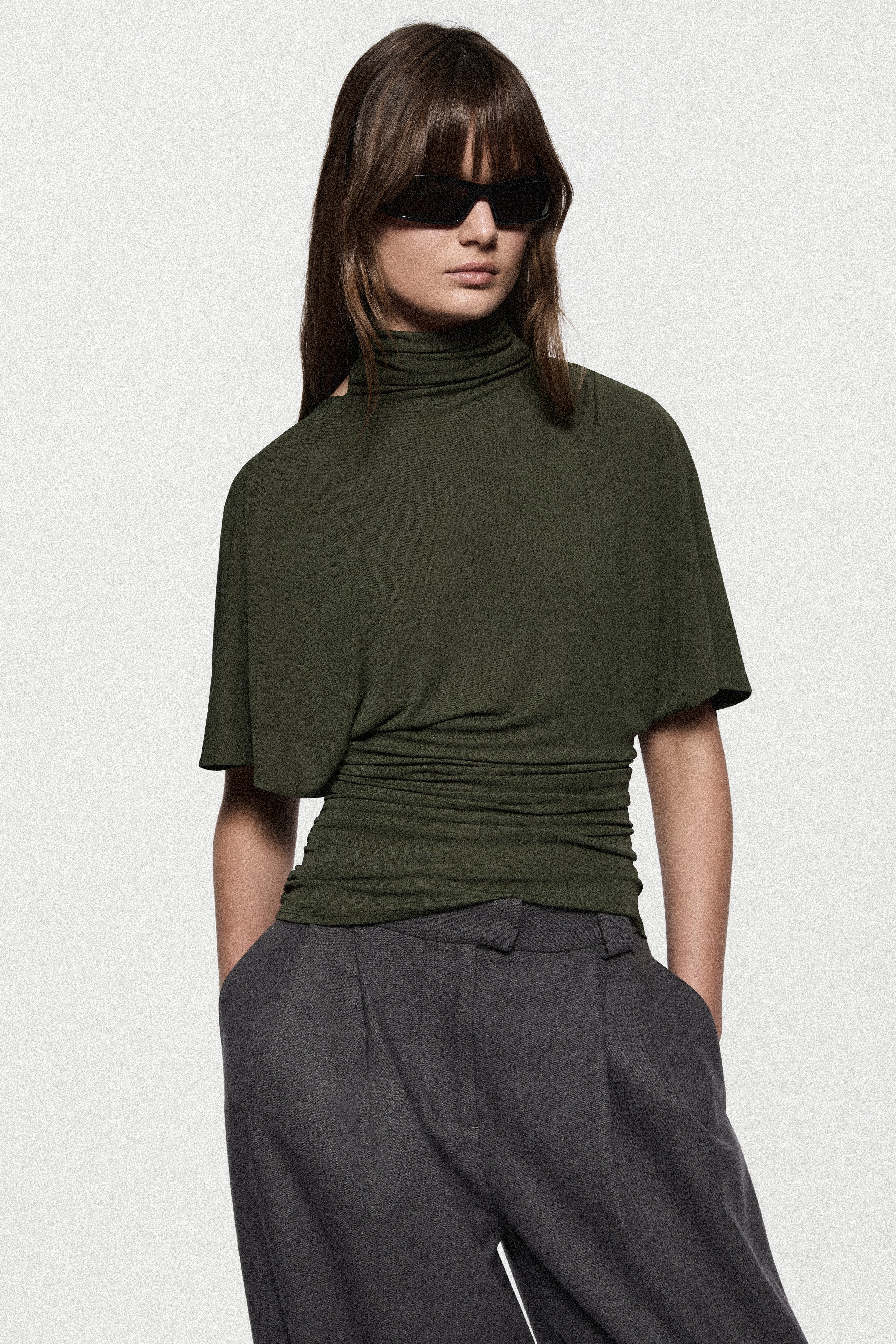 Hunter green cape jersey turtleneck top, short sleeves, ruched hem and folds.