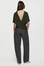Hunter green cape jersey top with open-back drape and short sleeves.