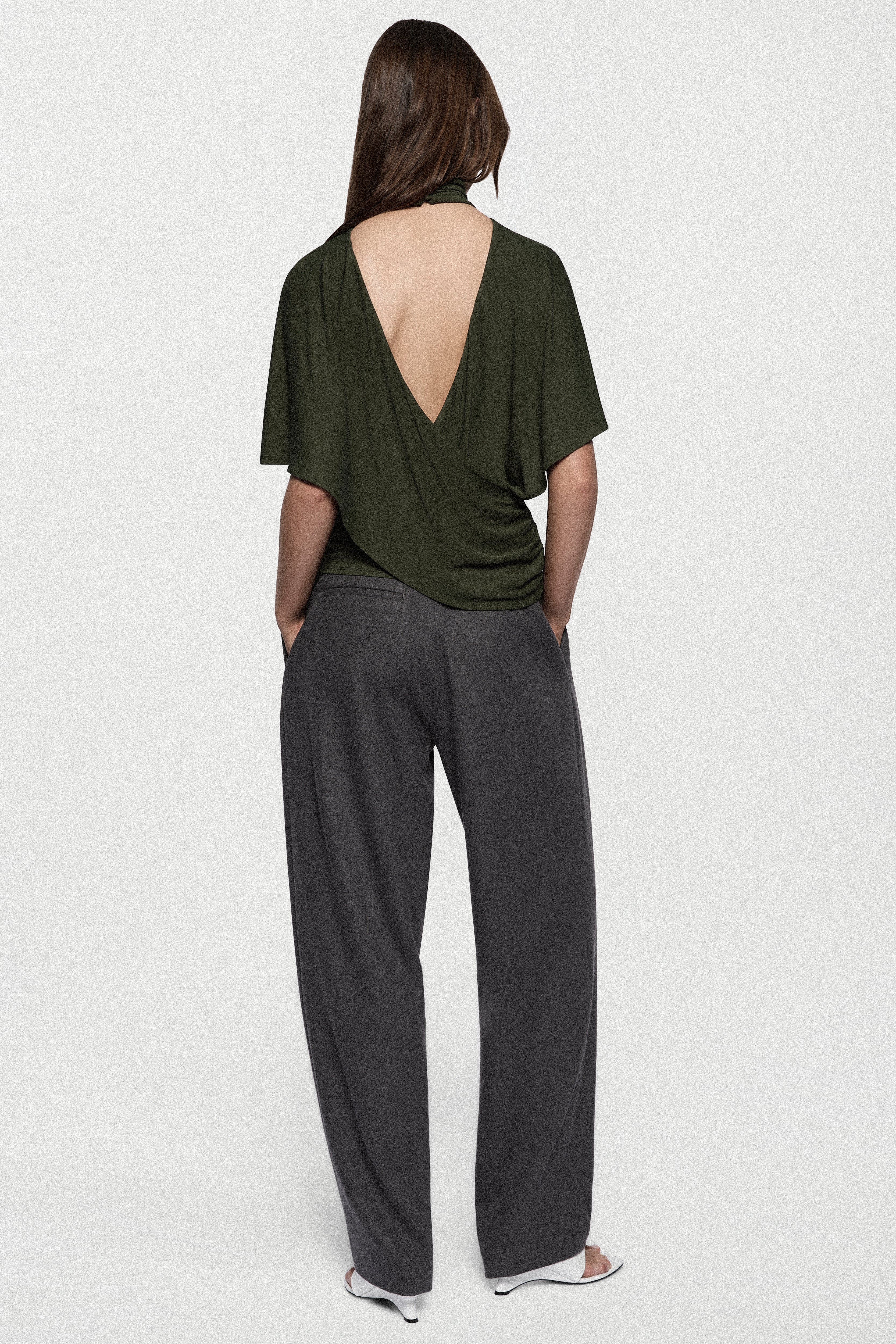 Hunter green cape jersey top with open-back drape and short sleeves.